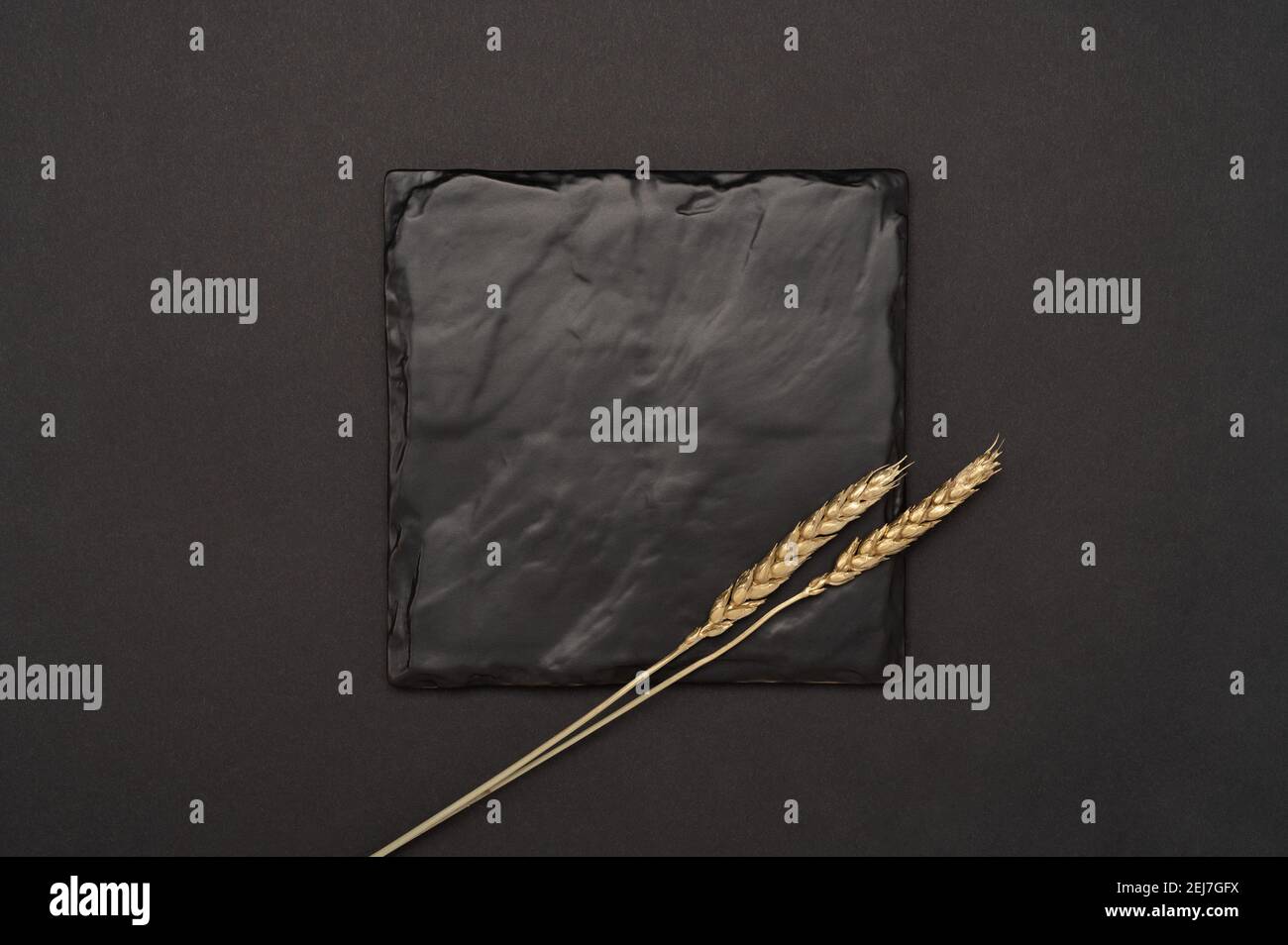 plaque ou tableau en ardoise noir carré pour le texte du menu ou de la recette sur une table noire. Maquette panneau vierge sur fond de table noir. Design minimaliste. Espace pour Banque D'Images