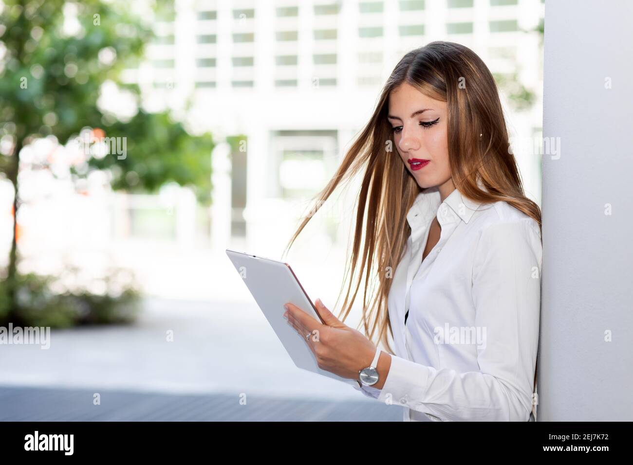 Smiling businesswoman using a digital tablet outdoor Banque D'Images