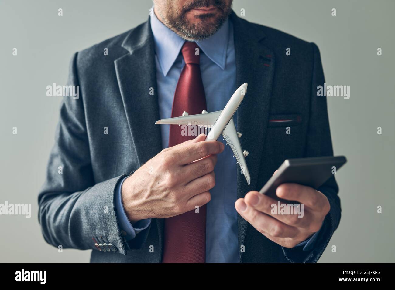Homme d'affaires réservant un billet d'avion en ligne à l'aide de l'application de téléphone mobile, image conceptuelle, mise au point sélective Banque D'Images