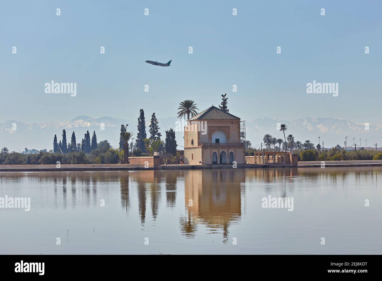 La Menara avec des montagnes de l'Atlas et un avion dans le ciel Banque D'Images