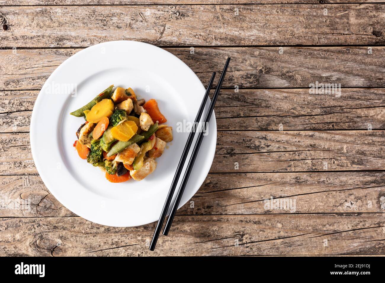 Faire sauter le poulet avec les légumes sur une table en bois rustique Banque D'Images