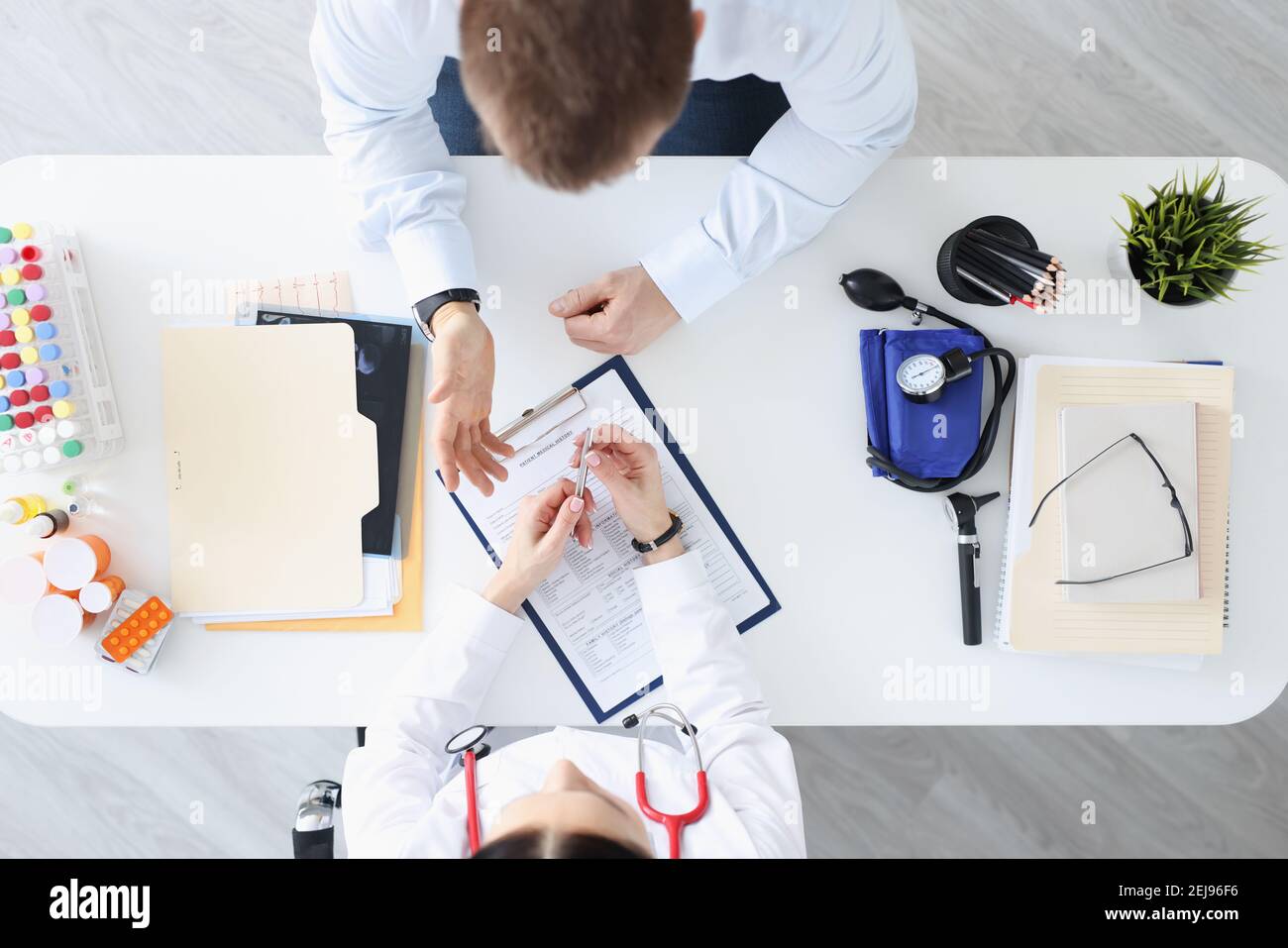 Médecin parlant au patient dans la vue de dessus du bureau Banque D'Images