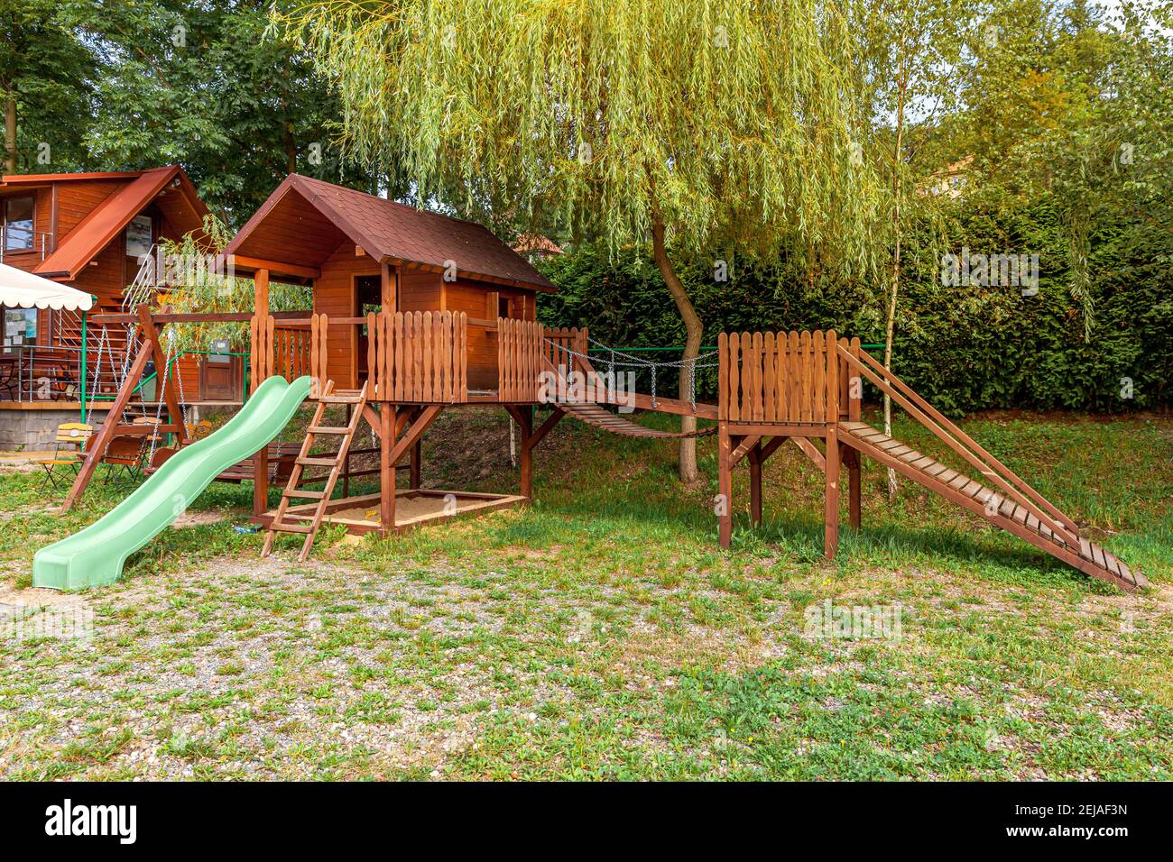 Aire de jeux en bois moderne et vide située sur une cour verte dans le parc public en été. Terrain de jeu amusant pour les enfants. Activités d'exercices urbains pour les enfants o Banque D'Images