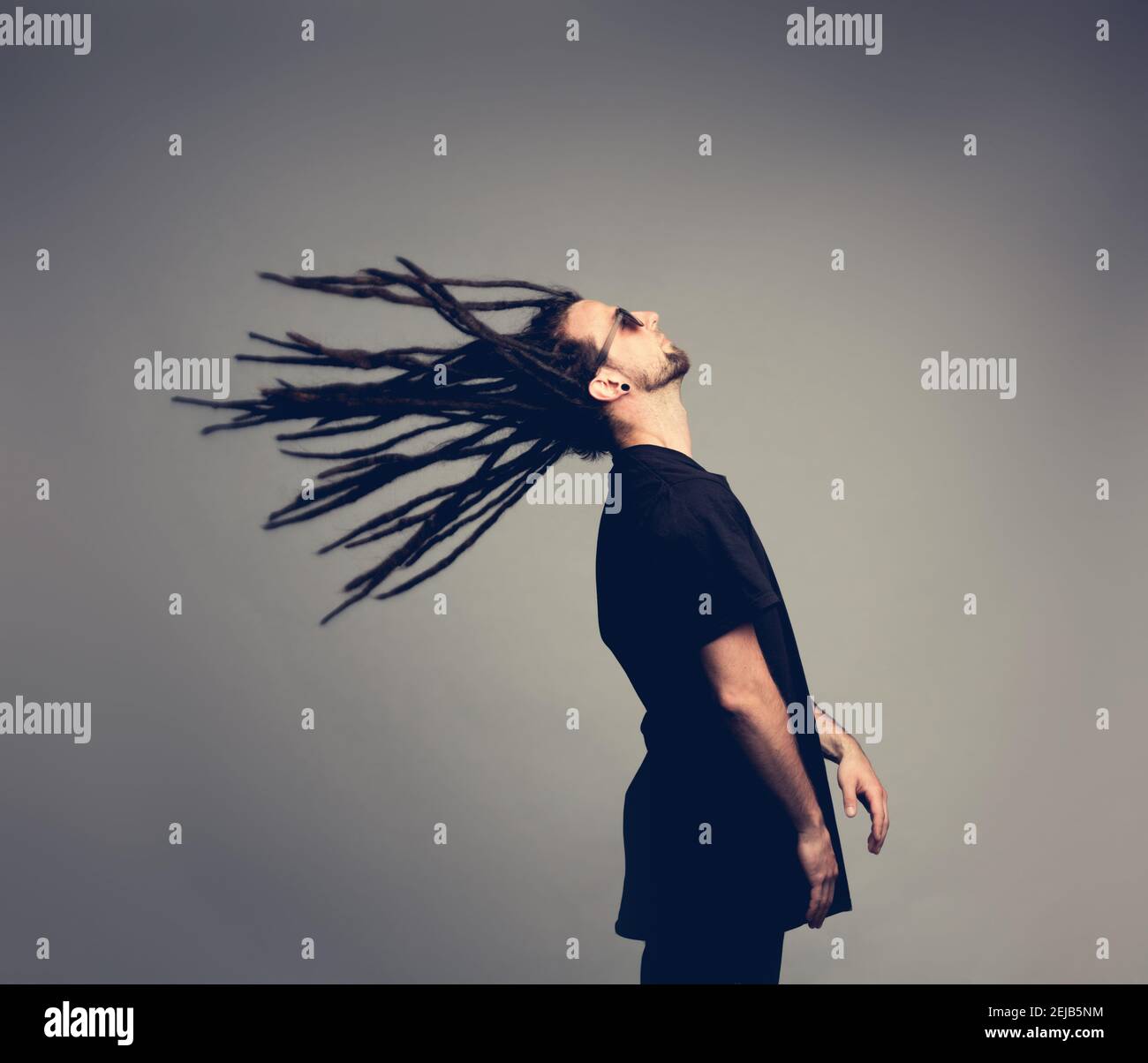 Un jeune homme qui retourne ses dreadlocks. Coiffure originale. Banque D'Images