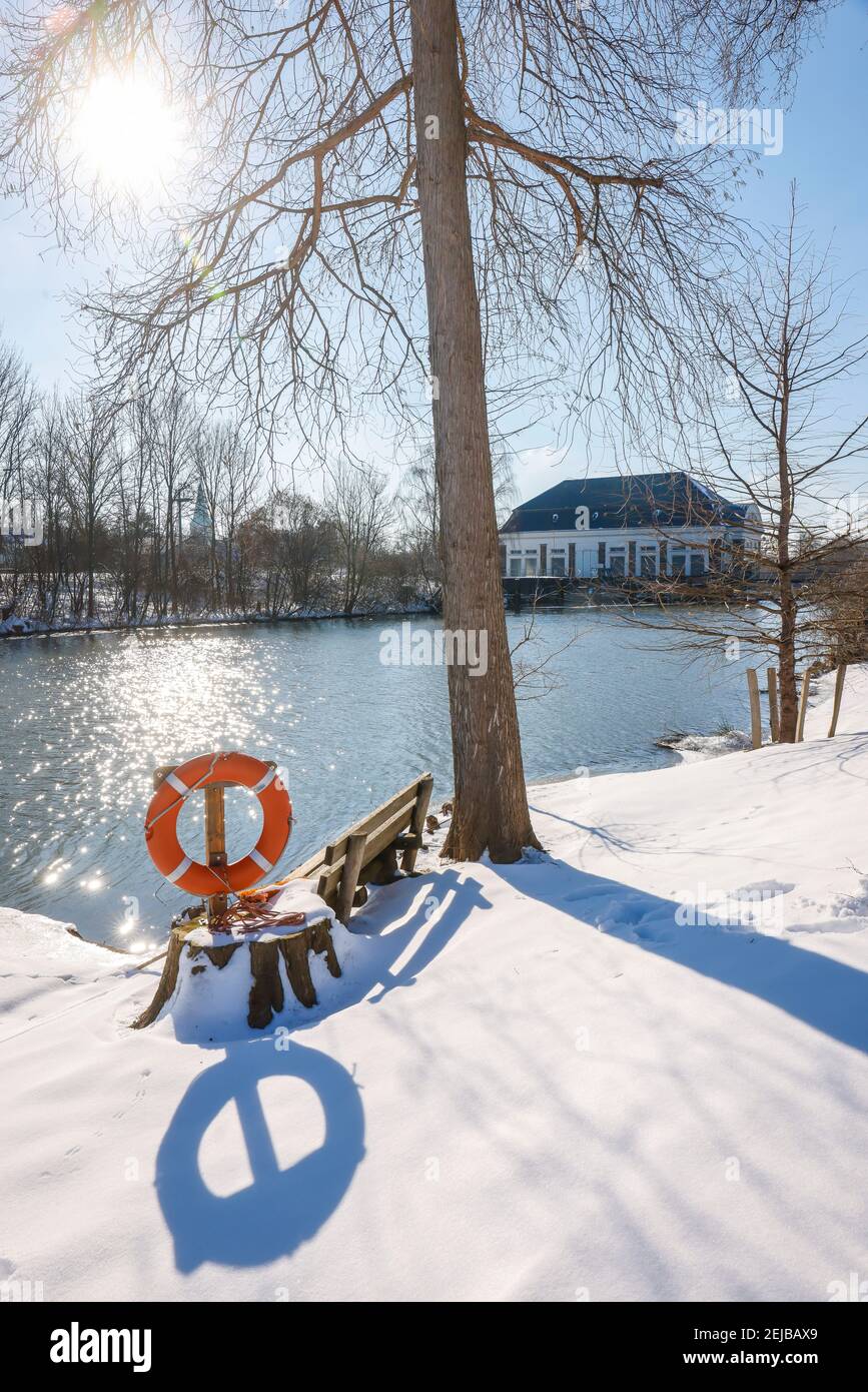 Hamm, Rhénanie-du-Nord-Westphalie, Allemagne - Ensoleillé paysage d'hiver dans la région de la Ruhr, glace et neige sur la rivière Lippe, banc de parc avec ceinture de sauvetage, dans le bac Banque D'Images