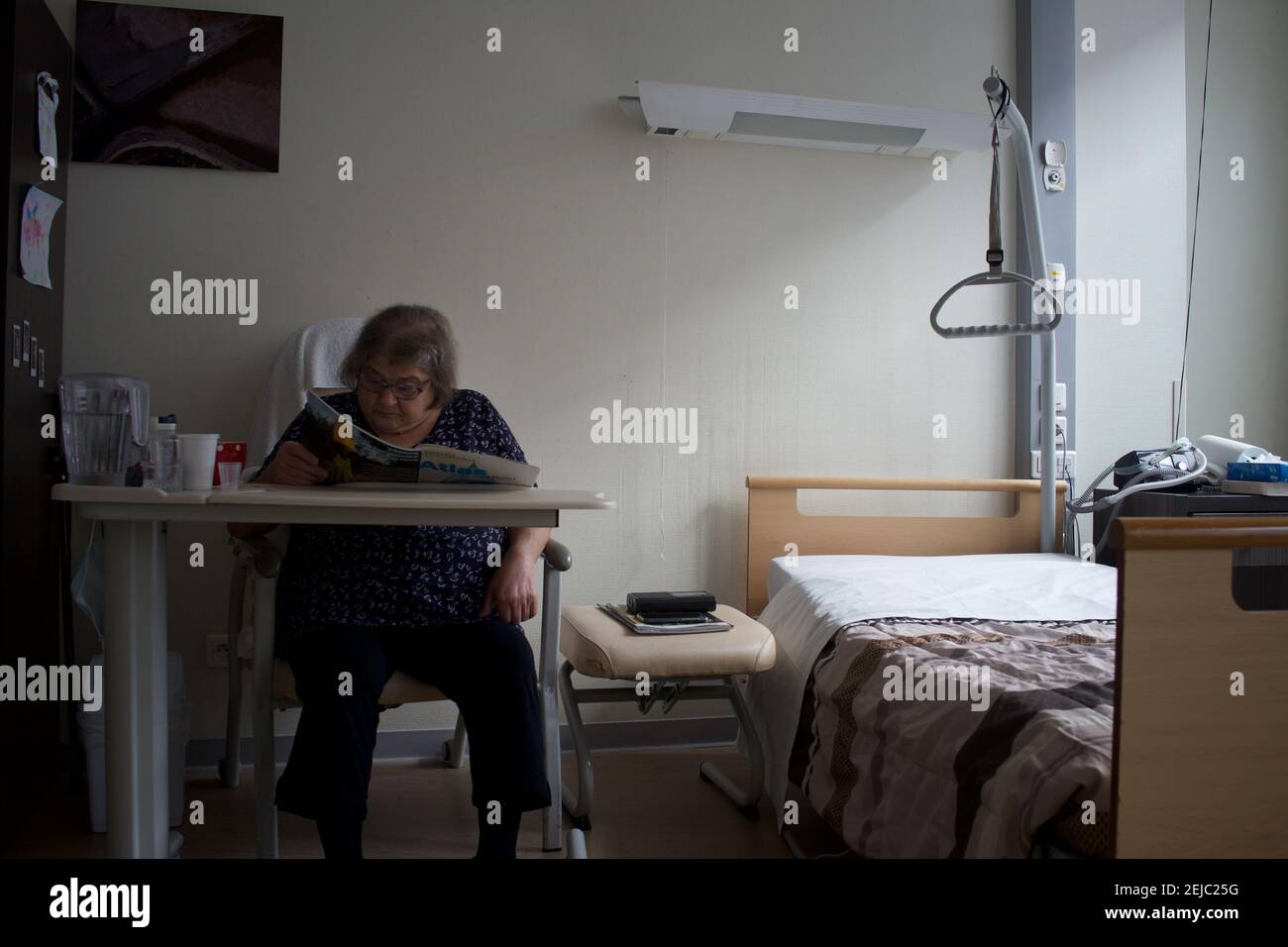 Patient dans la chambre, la lecture, la maison de soins en résidence - Paris, France Banque D'Images