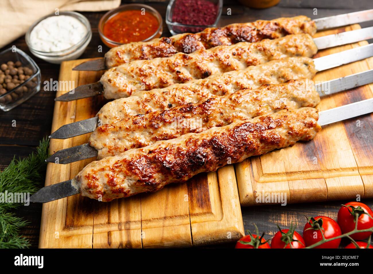 kebab fait de viande hachée sur brochette de métal avec légumes et sauce  sur fond de bois sombre Photo Stock - Alamy