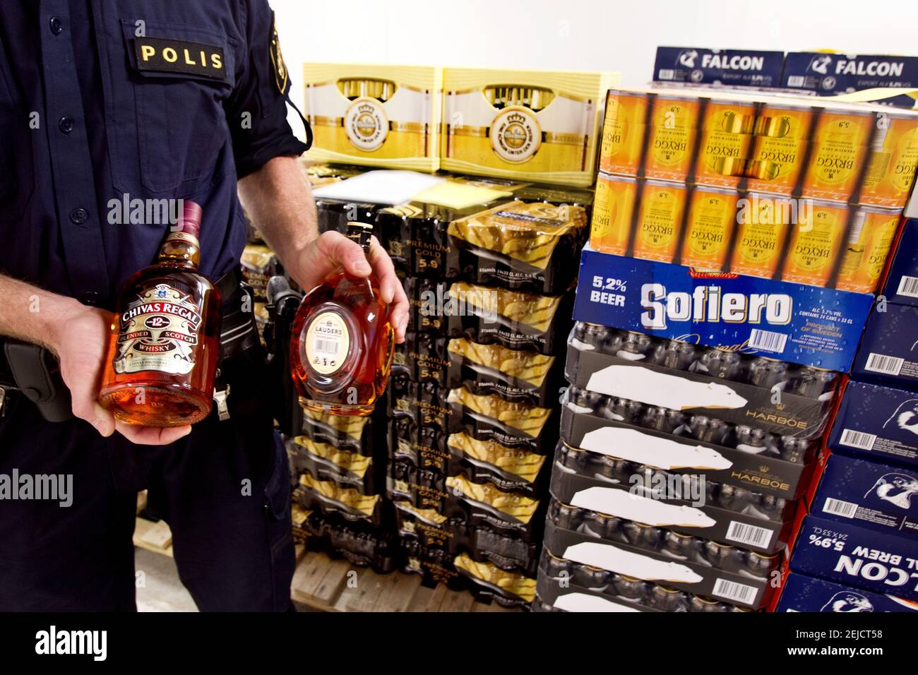 LINKÖPING, SUÈDE- 28 JANVIER 2014:UN policier montrant de l'alcool confisqué sous forme de bière et de spiritueux. Banque D'Images