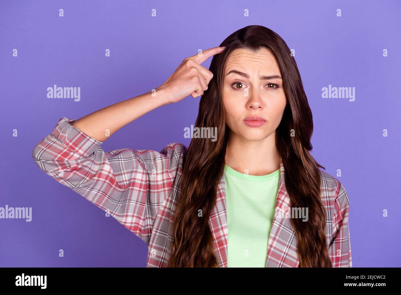 Photo de la jeune femme doutful esprit scratch tête de doigt lever sourcil  isolé sur fond violet Photo Stock - Alamy