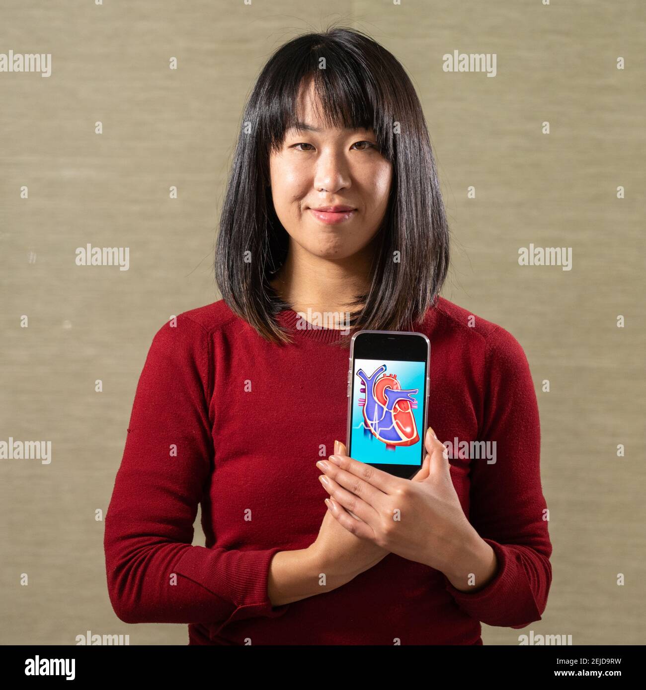 Femme tenant un écran avec un motif coeur découpé Banque D'Images