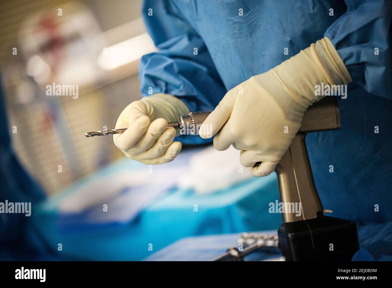 Salle d'opération : infirmière préparant un exercice pour l'installation d'une prothèse de genou (chirurgie orthopédique). Banque D'Images