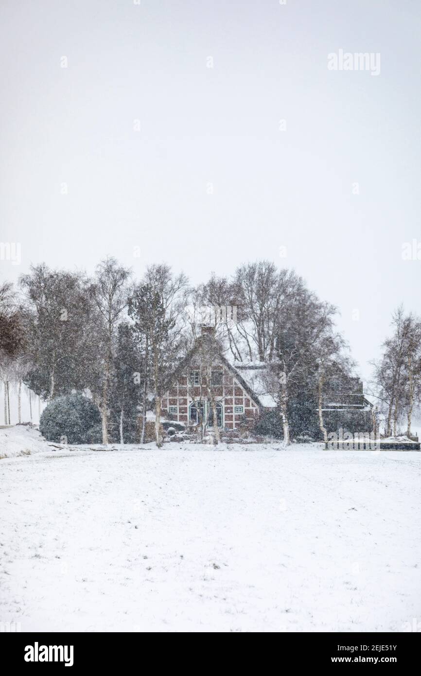Petit cottage à colombages dans de fortes chutes de neige Banque D'Images