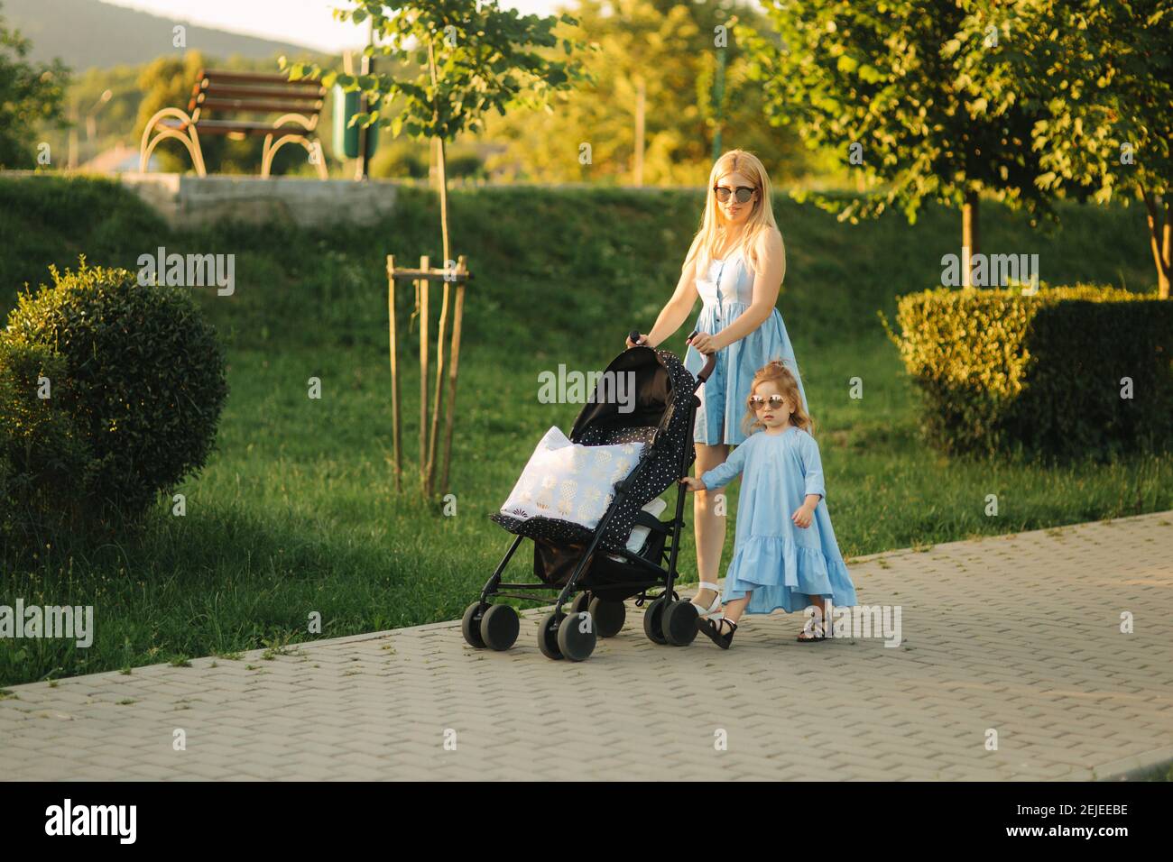 Petite Fille Aide Maman A Pousser Le Chariot De Bebe Bonne Famille Photo Stock Alamy