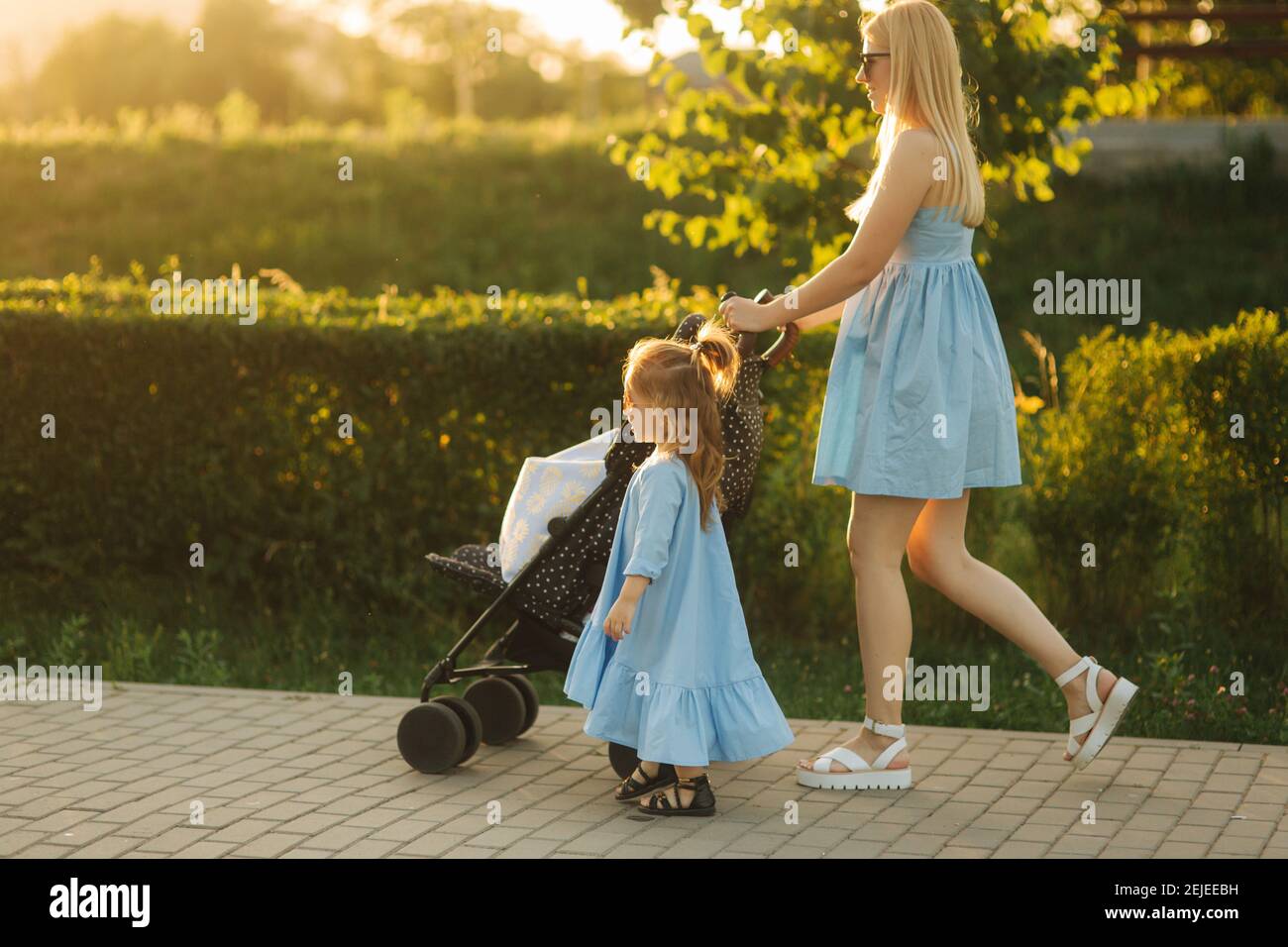 Petite Fille Aide Maman A Pousser Le Chariot De Bebe Bonne Famille Photo Stock Alamy
