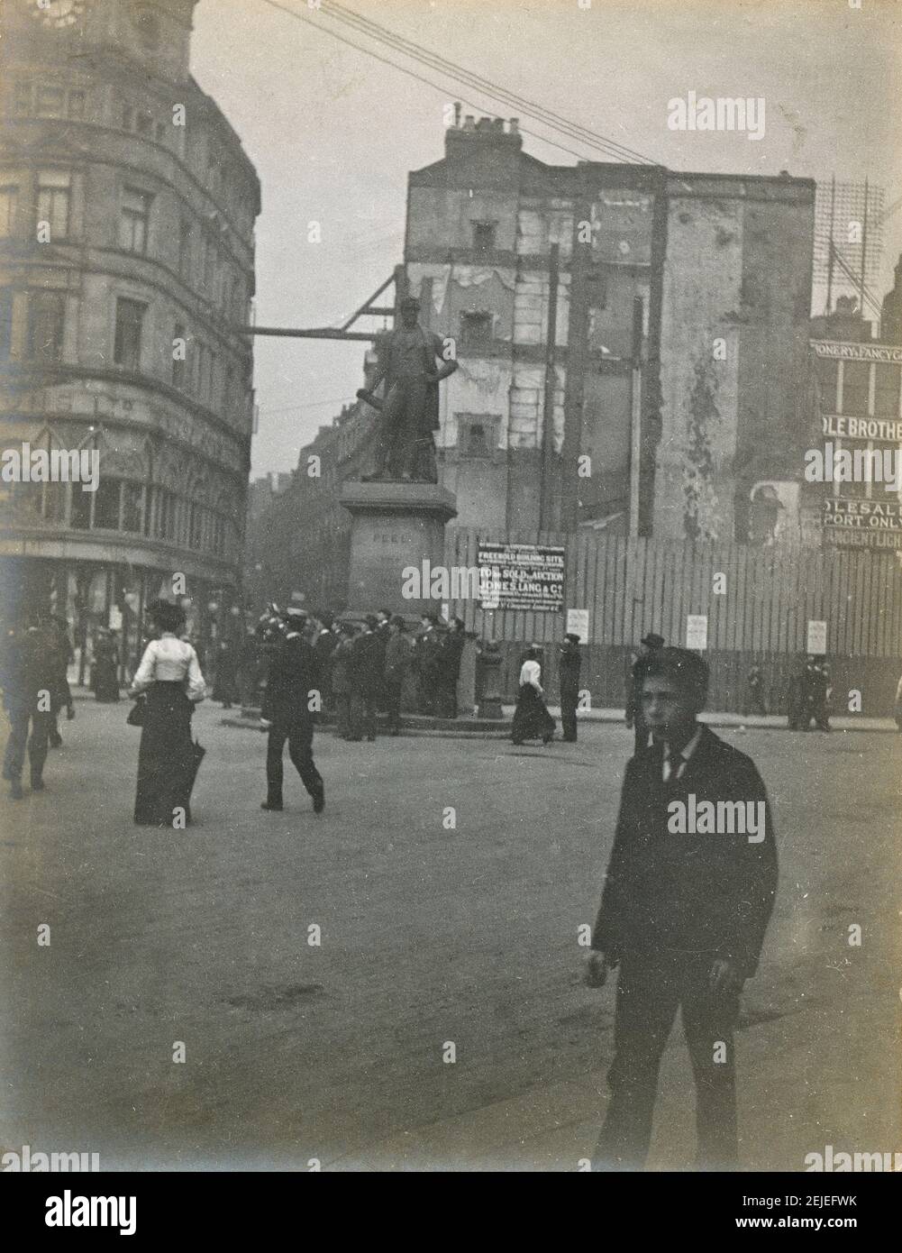 Photographie antique c1900, statue de Robert Peel à une intersection animée en Angleterre. Emplacement exact inconnu. L'enseigne de construction indique dans la partie « Freehold Building site, qui sera vendu à Auction, Jones Lang & Co. » SOURCE : PHOTO ORIGINALE Banque D'Images