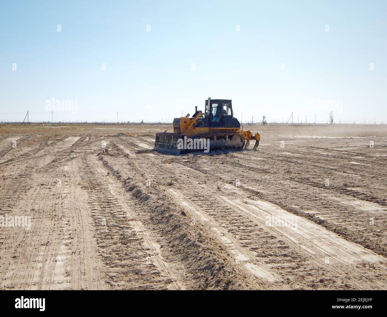 Le conducteur du tracteur nettoie la vitre. Le bulldozer dans les steppes nivele le site. Kazakhstan. Champ d'huile. Région de Mangistau. 17 août 2019 année. Banque D'Images