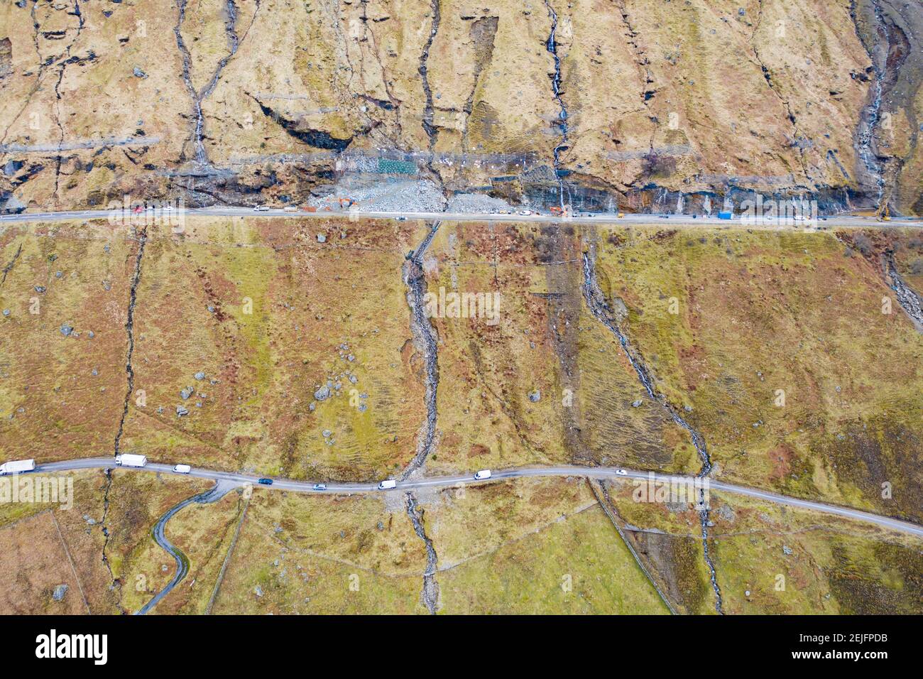 Glen Croe, Arrochar, Écosse, Royaume-Uni. 22 févr. 2021. Vue aérienne des travaux d'ingénierie préventive de glissement de terrain à A83 au repos et être reconnaissant Pass à Glen Croe. L'itinéraire important a été suivi par des glissements de terrain qui ont souvent fermé la route principale A83, forçant la circulation à utiliser la voie unique Old Military Road ci-dessous. Les derniers glissements de terrain ont même bloqué cette route. Actuellement, la circulation est escortée dans un sens dans les convois. Pic ; A83 haut et Old Military Road bas. Iain Masterton/Alay Live News Banque D'Images