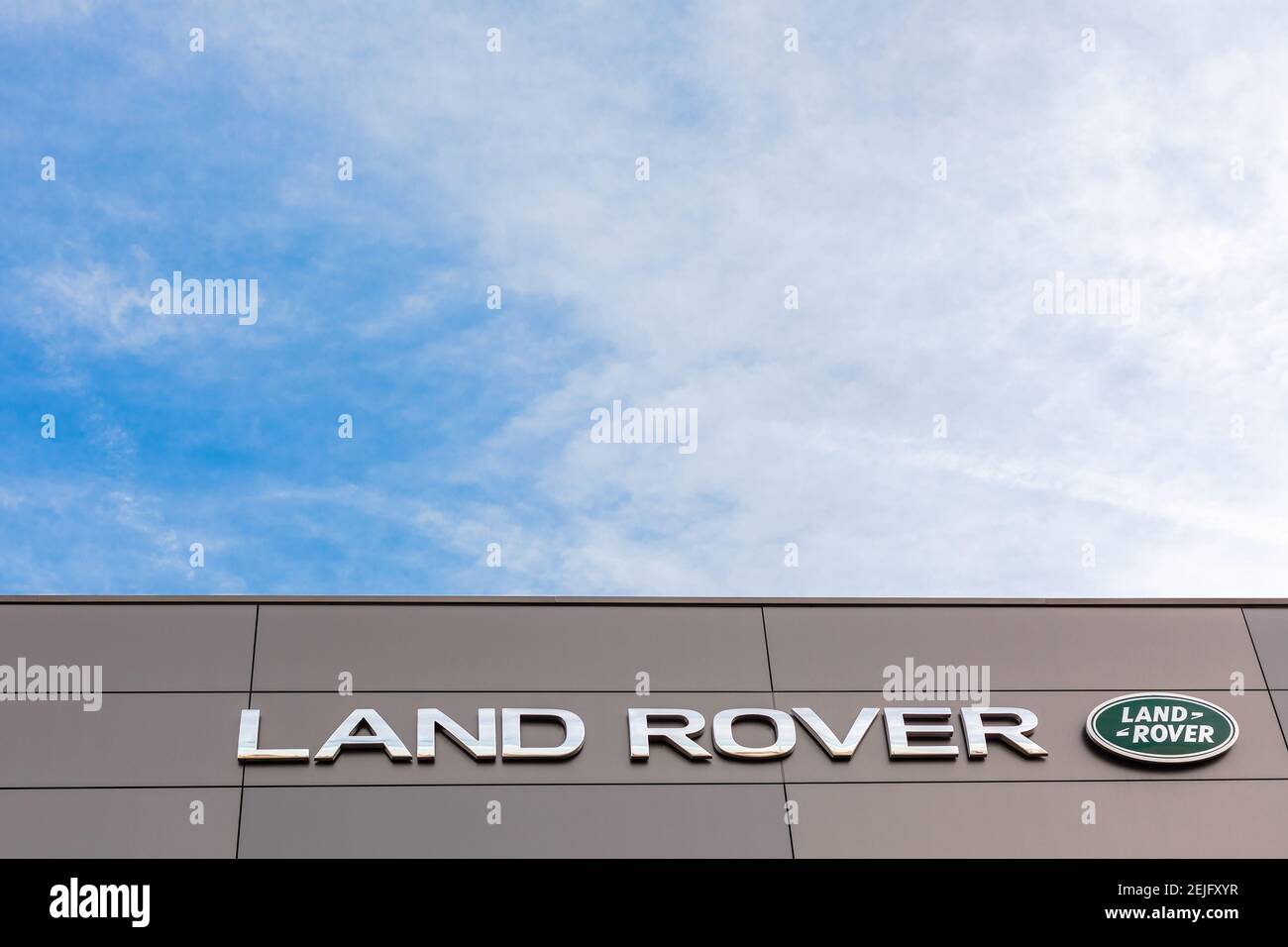 Logo de la marque Land Rover sur fond ciel bleu vif situé dans son bureau de concessionnaire à Lyon, France - 23 février 2020 Banque D'Images