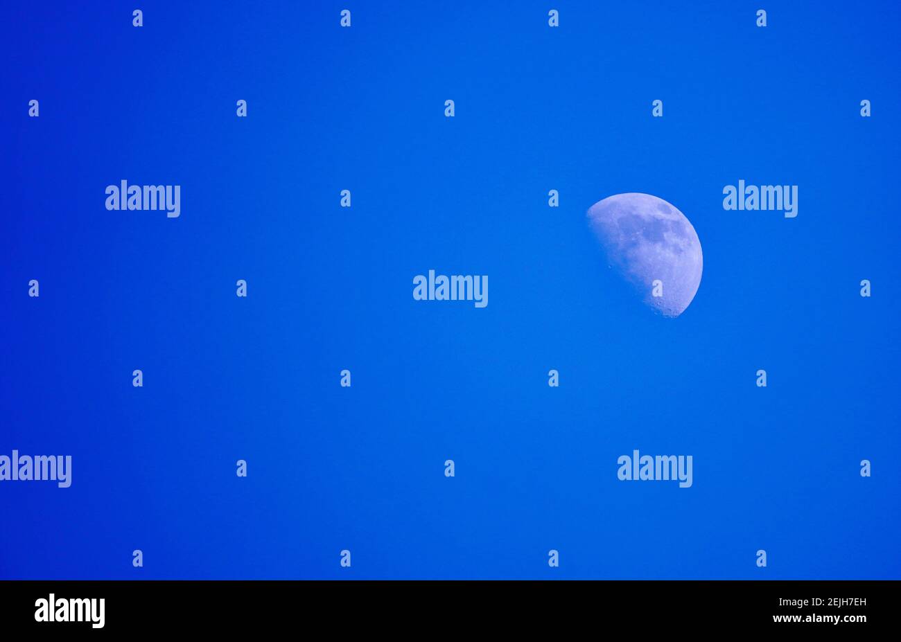 Lune dans le jour avec ciel bleu. Banque D'Images