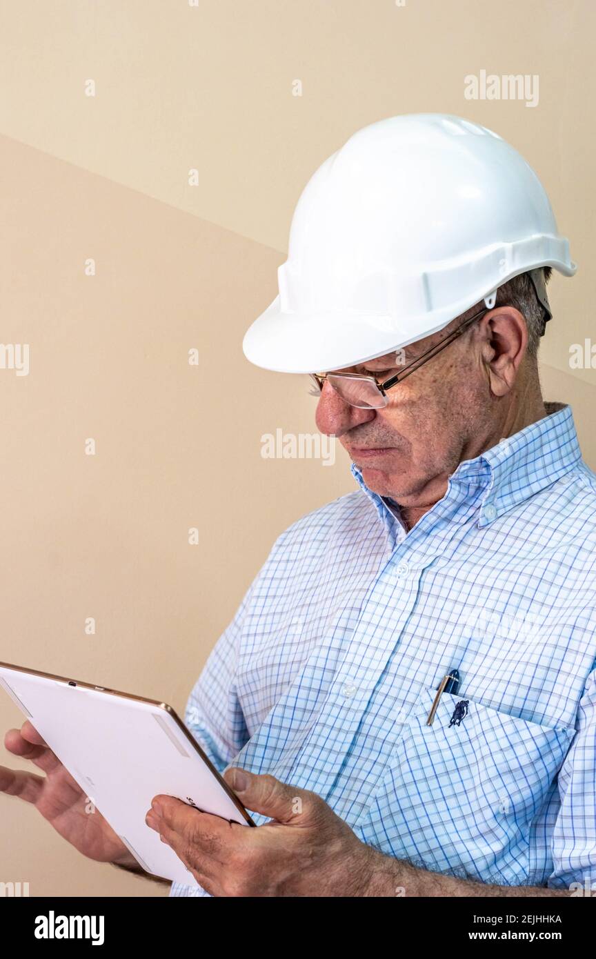 Ingénieur civil regardant le presse-papiers qu'il tient Banque D'Images