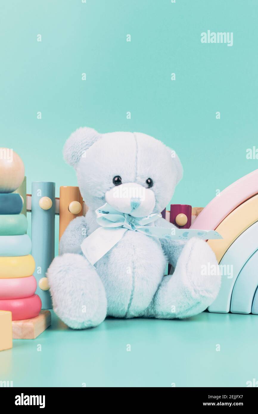 Collection de jouets pour enfants. Ours en peluche, arc-en-ciel en bois, avions, jouets éducatifs et musicaux pour bébés sur fond bleu clair Banque D'Images