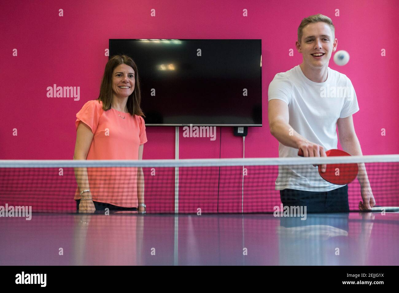 Une équipe joue au tennis de table dans leur réunion de bureau moderne espace pour s'amuser Banque D'Images