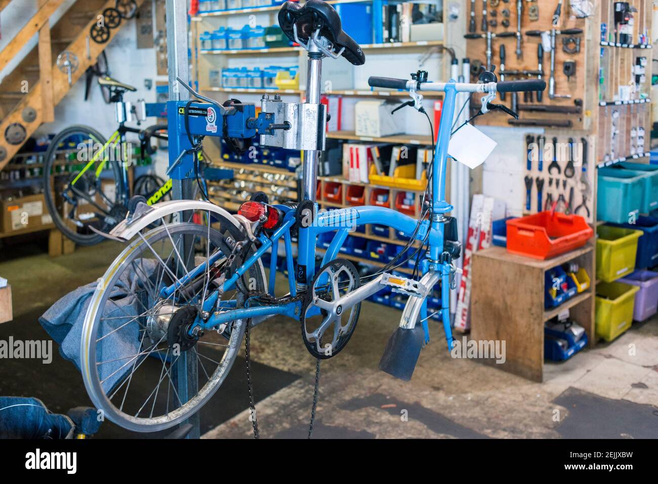 Un vélo Brompton est en train d'être entretenu sur un poste de travail de vélo dans une boutique de vélo Banque D'Images