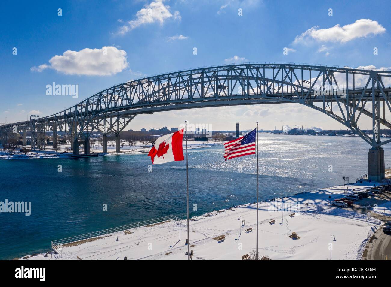 Port Huron, Michigan - les drapeaux des États-Unis et du Canada volent au Blue Water Bridge, qui relie les États-Unis (à droite) et le Canada au-dessus de St. Banque D'Images