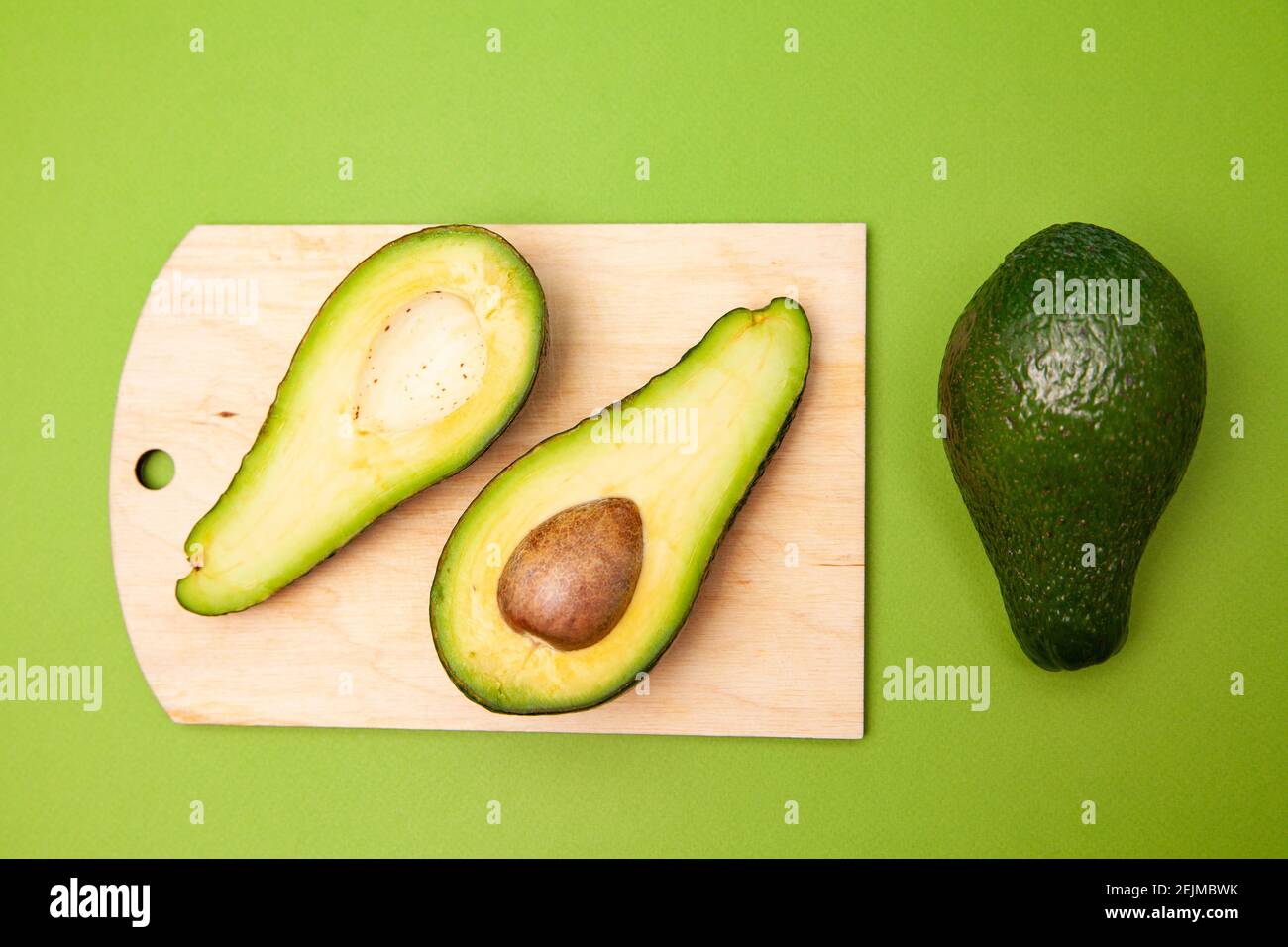 Délicieux fruits frais d'avocat disposés sur une surface verte Banque D'Images