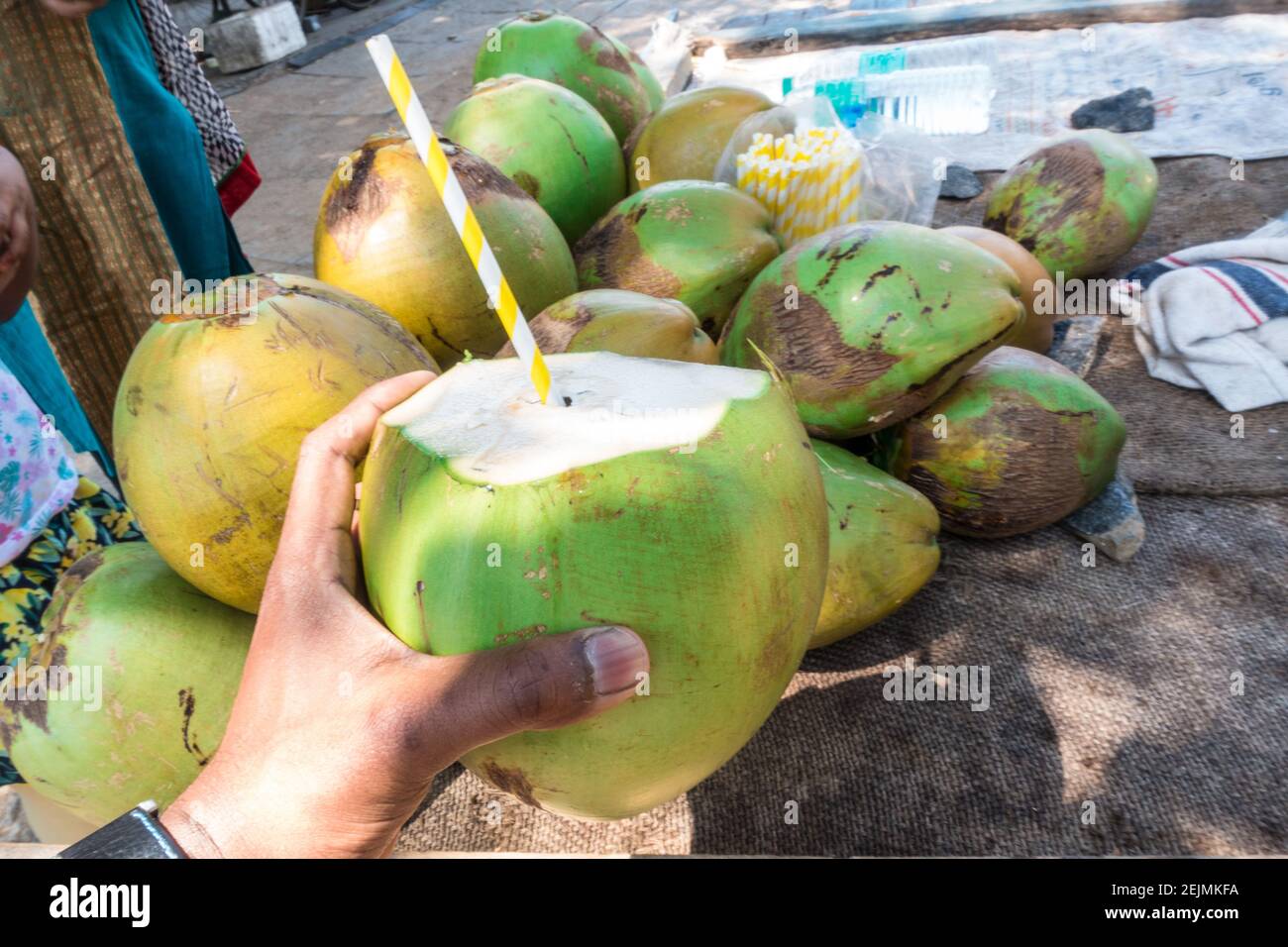 Homme achetant une noix de coco tendre avec de la paille de papier Banque D'Images