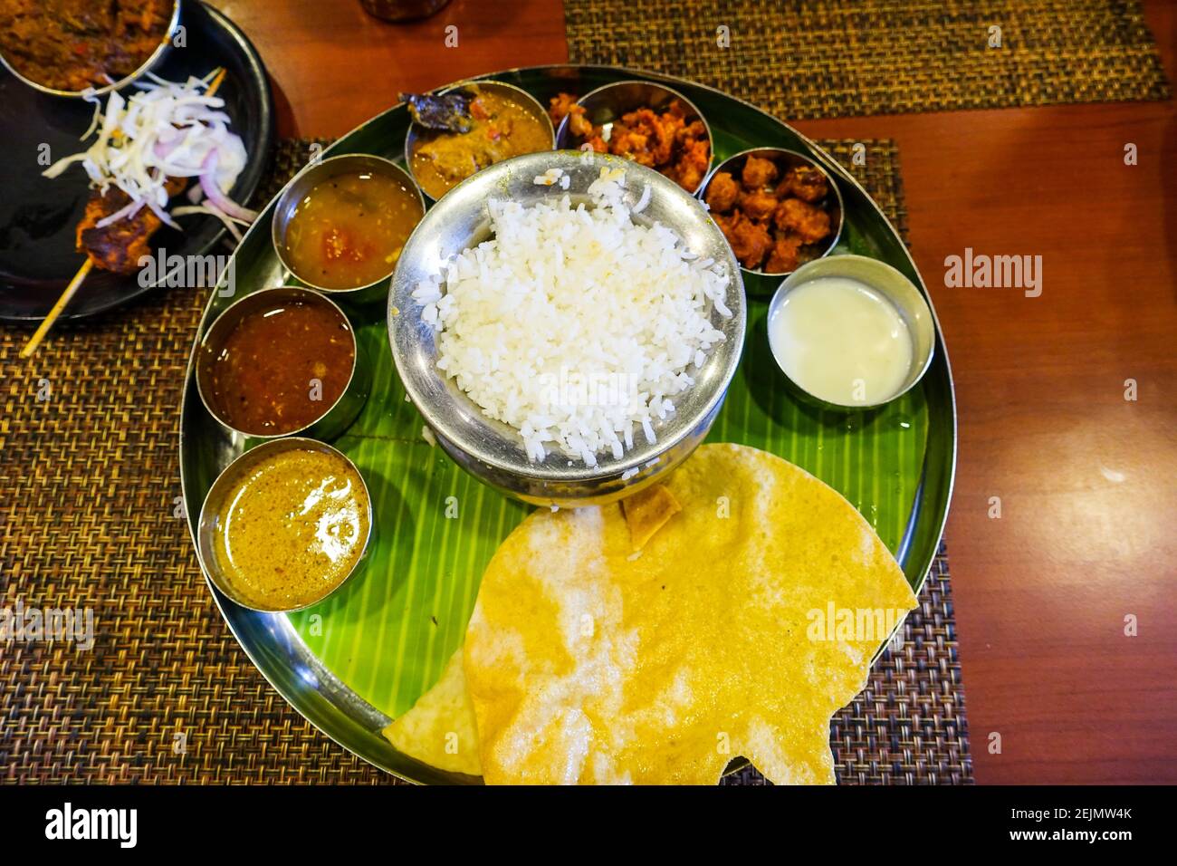 Nourriture sud-indienne sur une assiette au-dessus de la feuille de  plantain avec petites tasses remplies de curry Photo Stock - Alamy