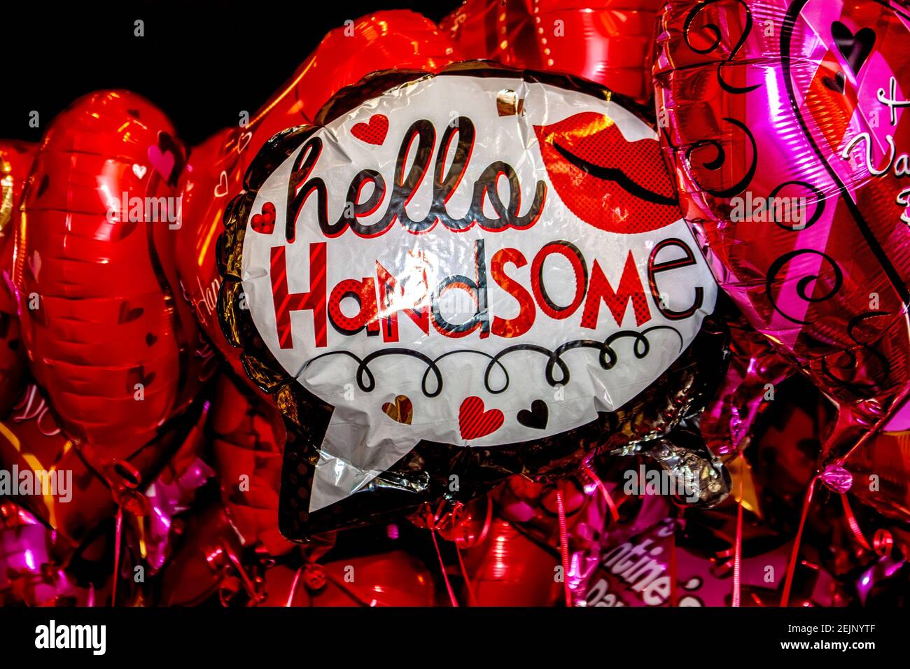 Gros plan d'un tas de ballons mylar en rose et Rouge avec un au milieu qui lit Bonjour beau - foyer sélectif Banque D'Images