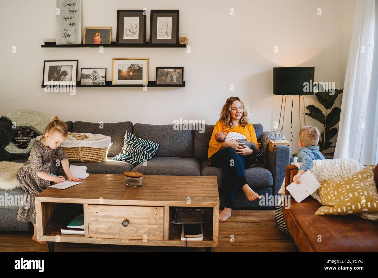 Bonne Maman Dans Le Salon Allaitant Bebe Et Parlant A Enfants Plus Ages Photo Stock Alamy
