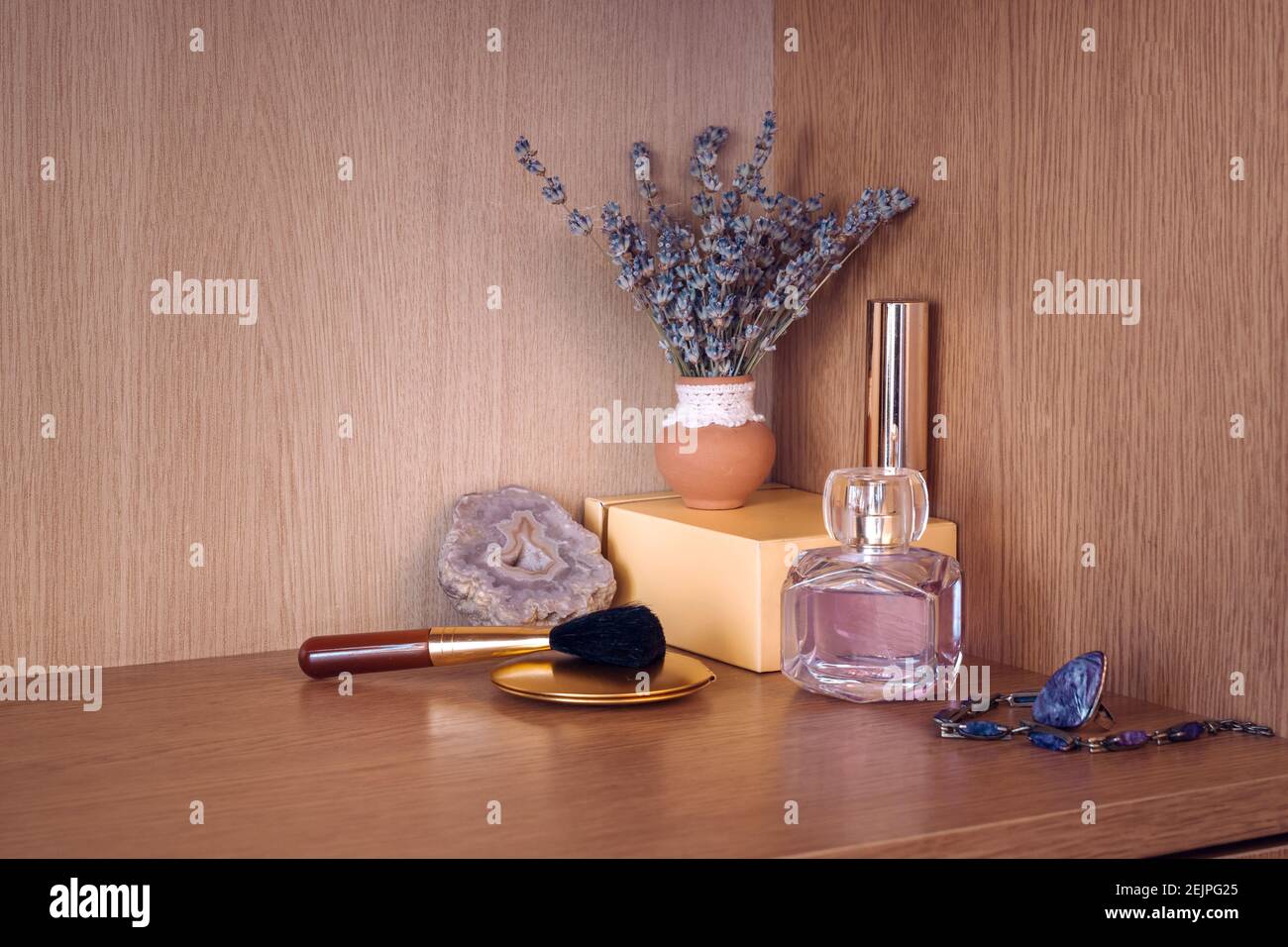 Produits de beauté avec bijoux par vase de fleur de lavanda Banque D'Images