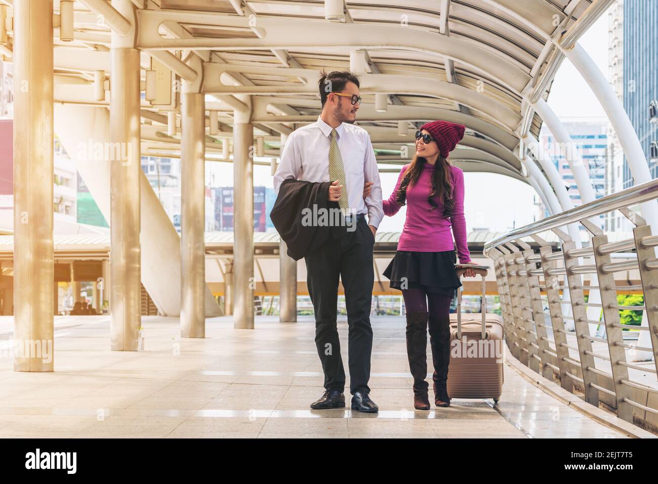 Couple voyageurs marchant dans le passage du terminal de l'aéroport avec sac de voyage ou bagages pour voyage de lune de miel à l'étranger. Concept de voyage en couple. Banque D'Images