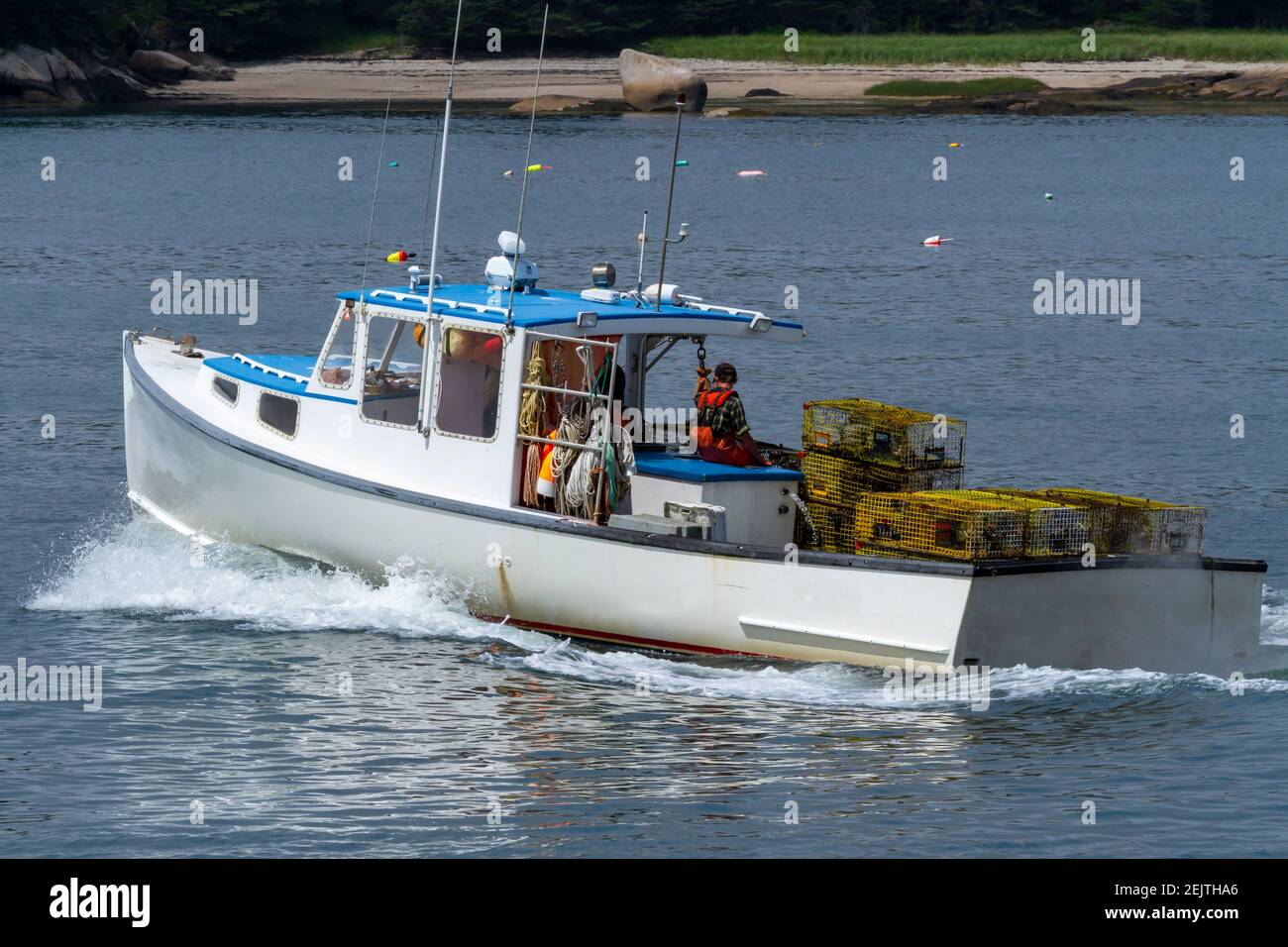Un bateau de homard avec des pièges se dirigeant vers l'extérieur pour vérifier ses pièges. Banque D'Images