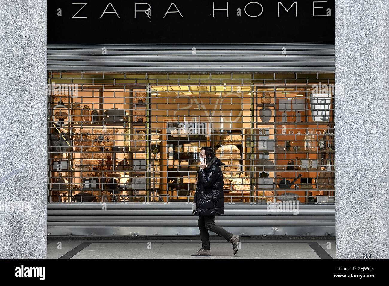 TURIN, ITALIE - 12 mars 2020 : un homme portant un masque respiratoire  passe devant un magasin Zara Home. Le gouvernement italien a fermé la  majorité des magasins pour stopper la propagation