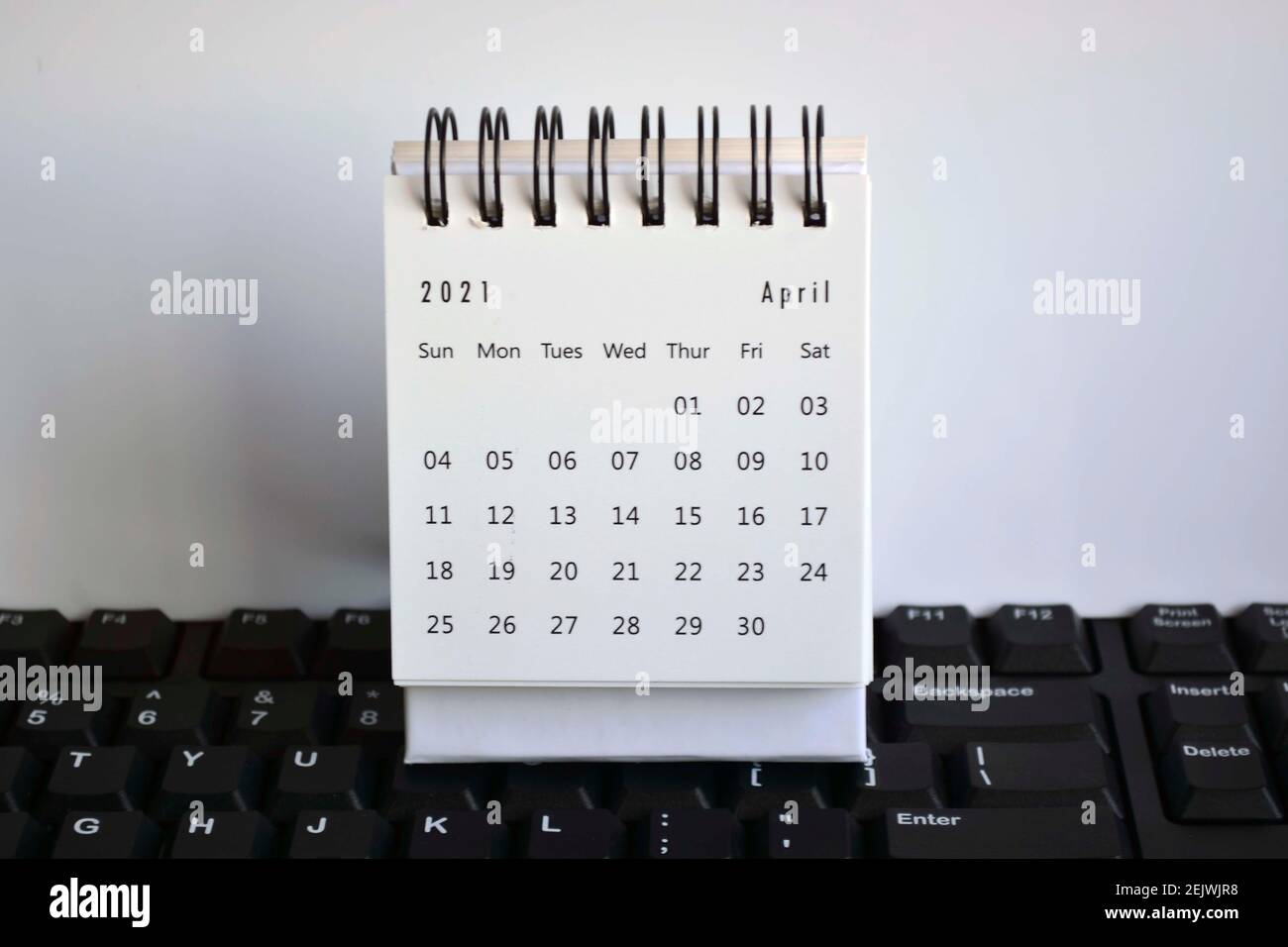Calendrier blanc d'avril 2021 sur un clavier à arrière-plan blanc Banque D'Images