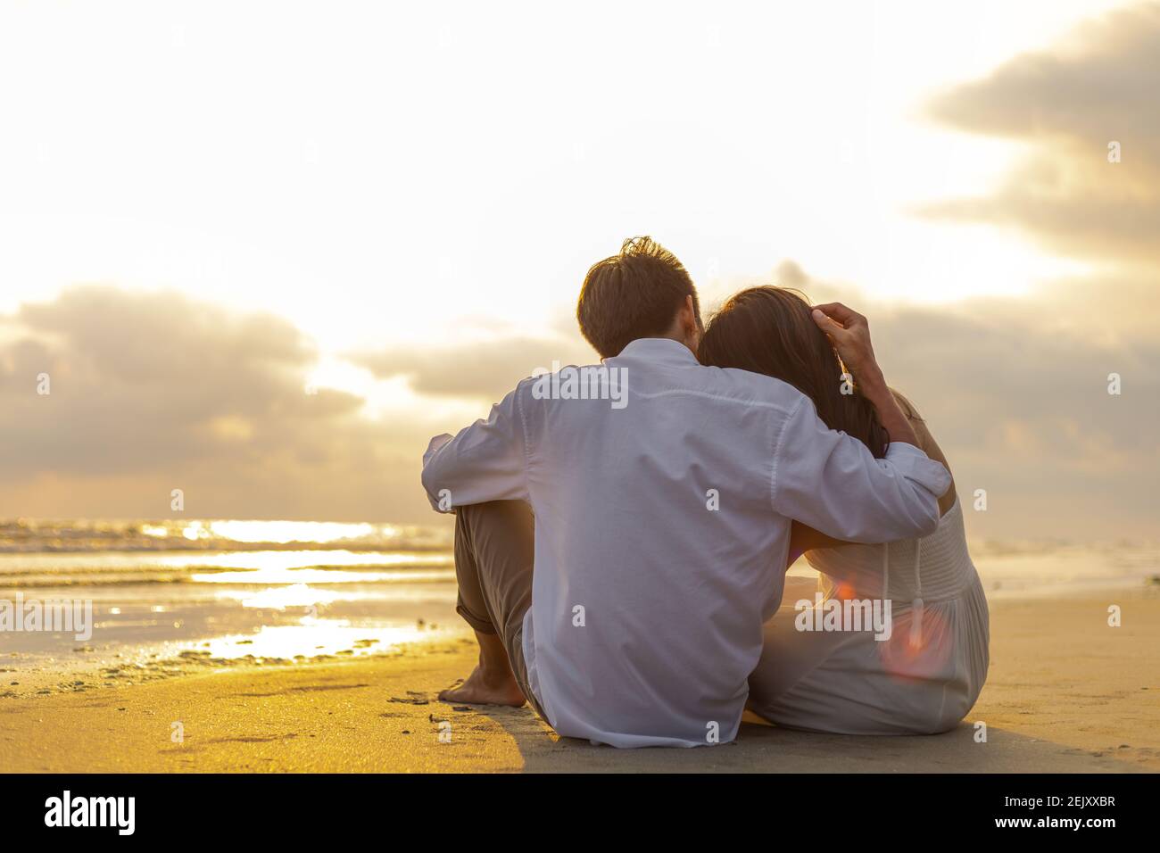 Couple amoureux regardant le coucher du soleil ensemble sur la plage Voyage  vacances d'été. Concept romantique Photo Stock - Alamy