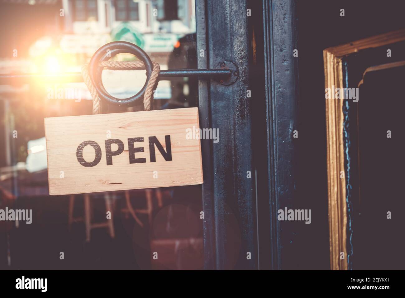 Un panneau d'affaires indiquant « Open » sur le café ou le restaurant est accroché à la porte d'entrée. Tons vintage. Banque D'Images