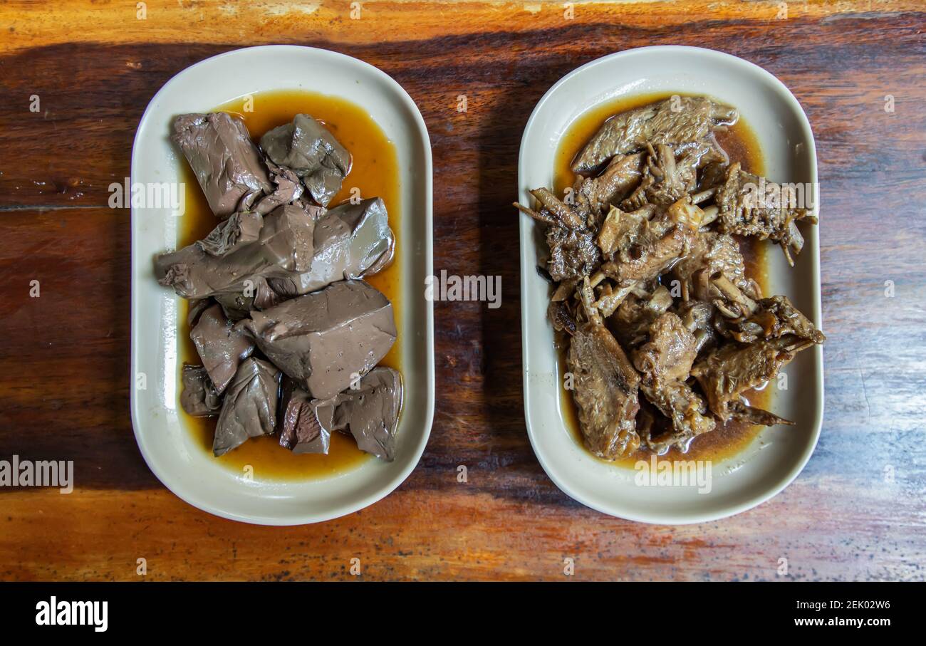 Gelée de sang de canard et aile de canard bouillie se déversant dans la sauce soja sur une table en bois. Hors-d'œuvre, concentration sélective. Banque D'Images