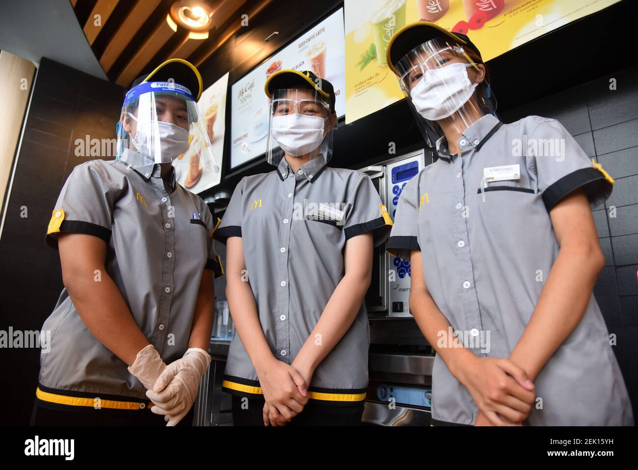 Par mesure de précaution, les employés de McDonald's portent un masque de  protection et un écran facial pendant la pandémie Covid-19. Le restaurant  McDonald's de Bangkok propose uniquement des plats à emporter