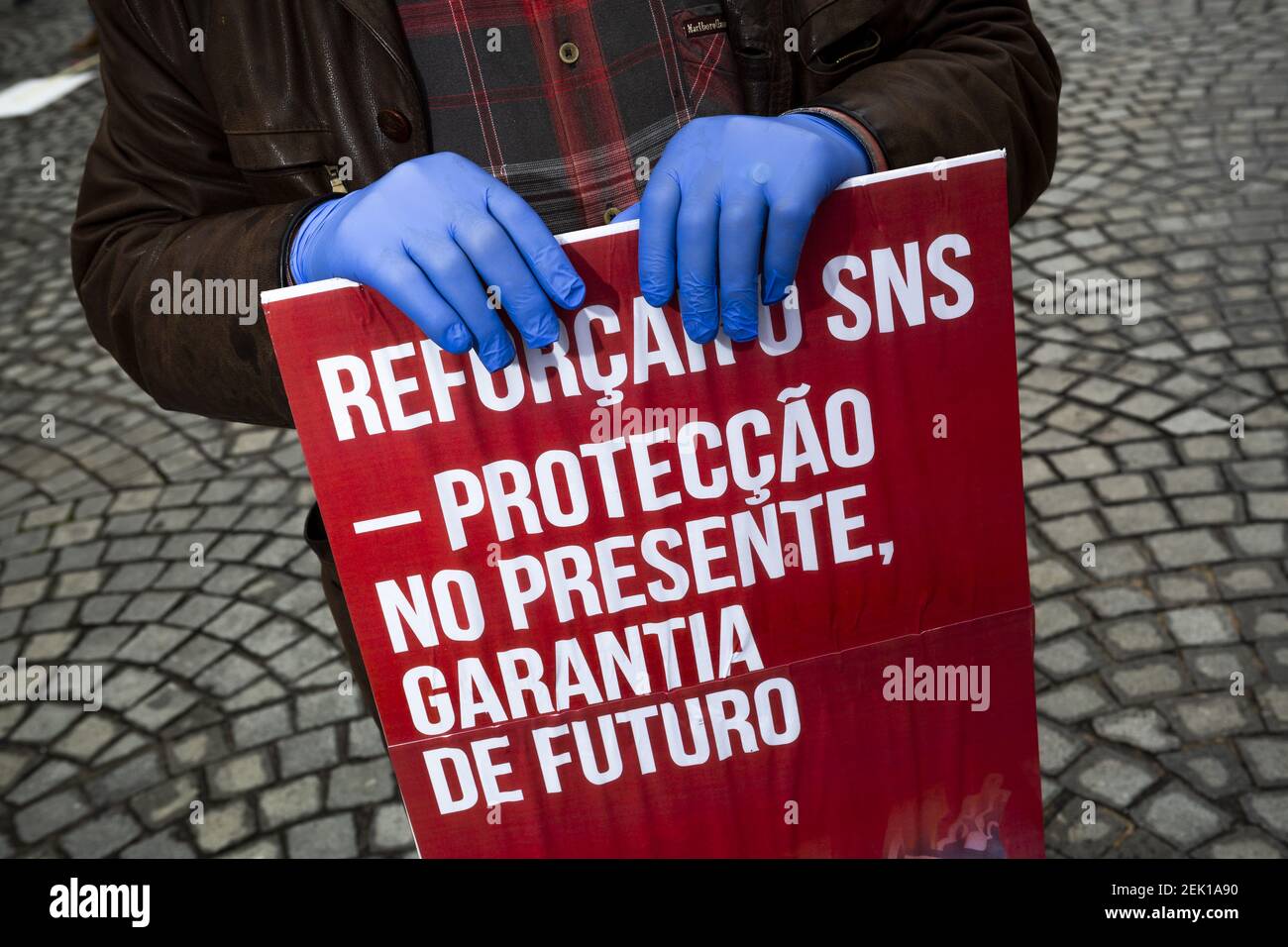 Un manifestant tenant un écriteau tout en portant des gants par mesure de précaution contre le covid 19, pendant la démonstration. Le syndicat des travailleurs a célébré la fête du travail par une protestation silencieuse à Porto et a suivi la plupart des mesures de confinement du coronavirus. Ils exigent une attention particulière aux violations des droits des travailleurs qui ont été commises avec l'excuse de la pandémie. (Photo par Diogo Baptista / SOPA Images / Sipa USA) Banque D'Images