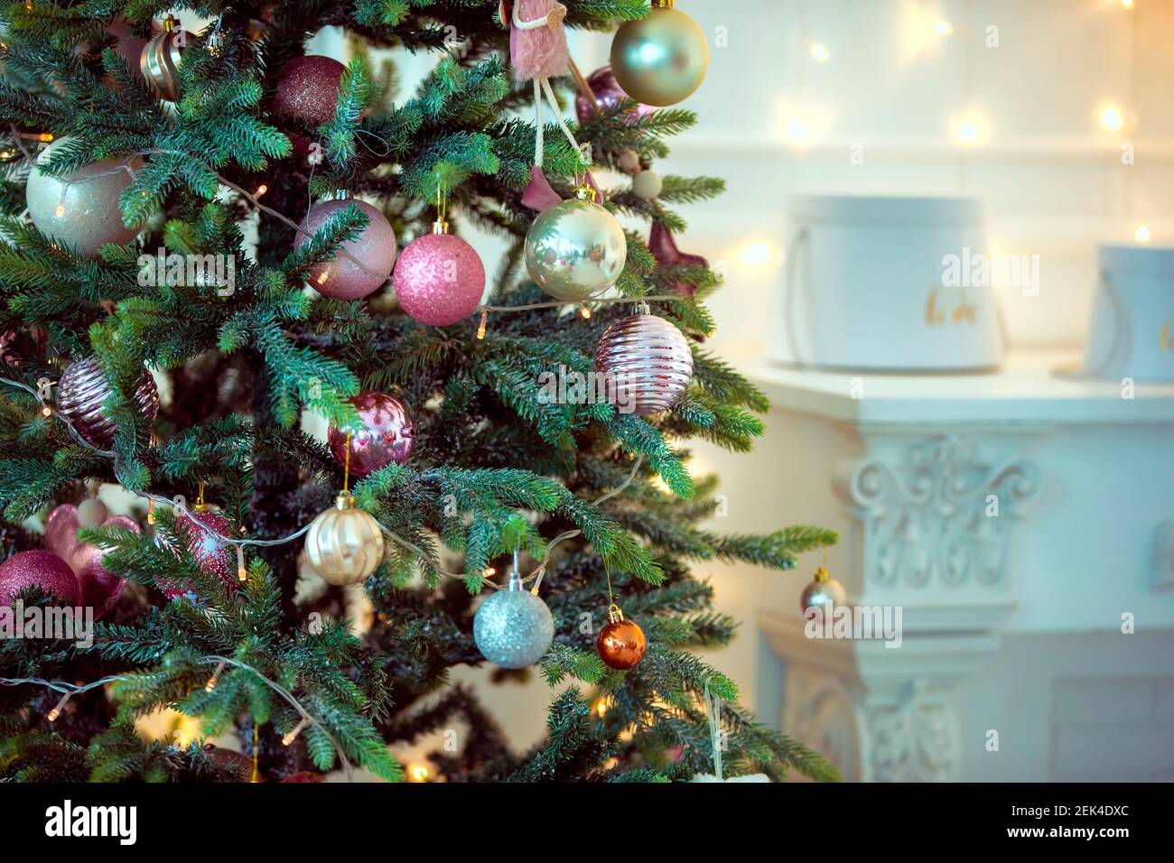 Arrière-plan de Noël. Partie de l'arbre de Noël décorée de boules et de guirlandes sur un fond clair. Banque D'Images