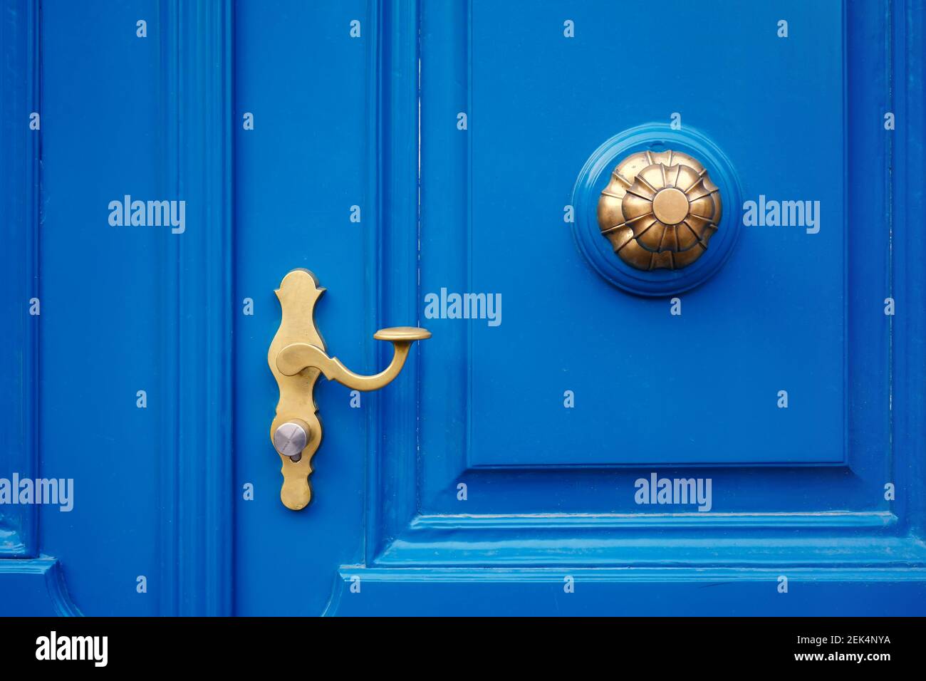 Gros plan d'une porte bleue avec poignée de porte dorée et poignée de porte vintage. Banque D'Images