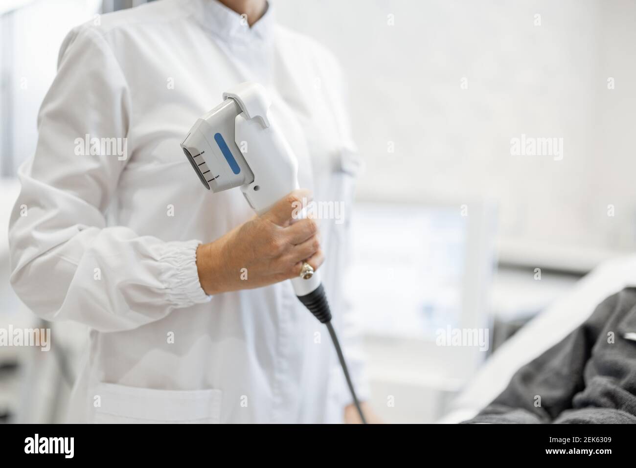 Cosmétologue en robe blanche avec patient en salon de cosmétologie Banque D'Images