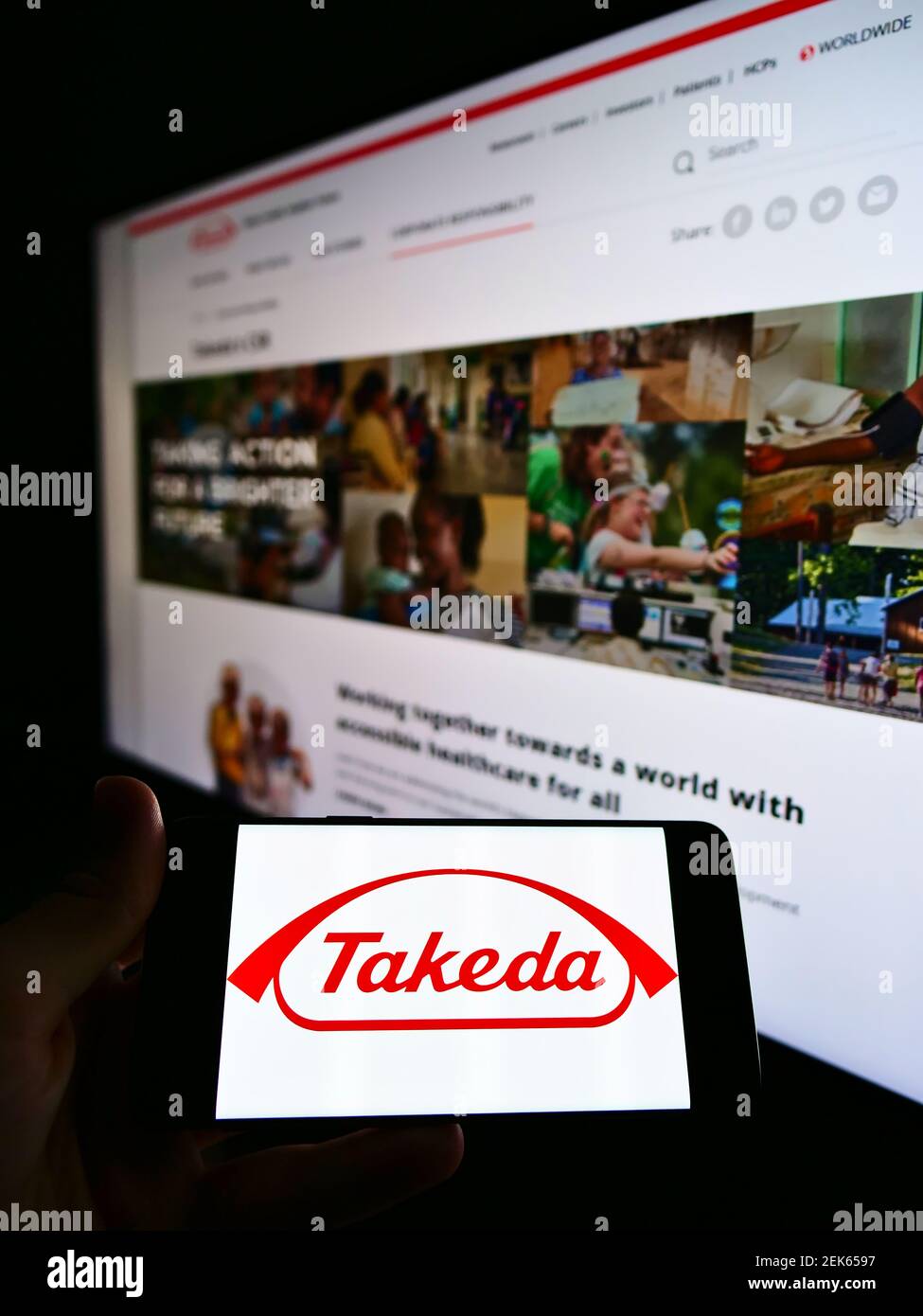 Personne tenant un smartphone avec le logo d'entreprise de la société japonaise Takeda Pharmaceutical Company Ltd à l'écran devant le site Web. Concentrez-vous sur l'affichage du téléphone portable. Banque D'Images
