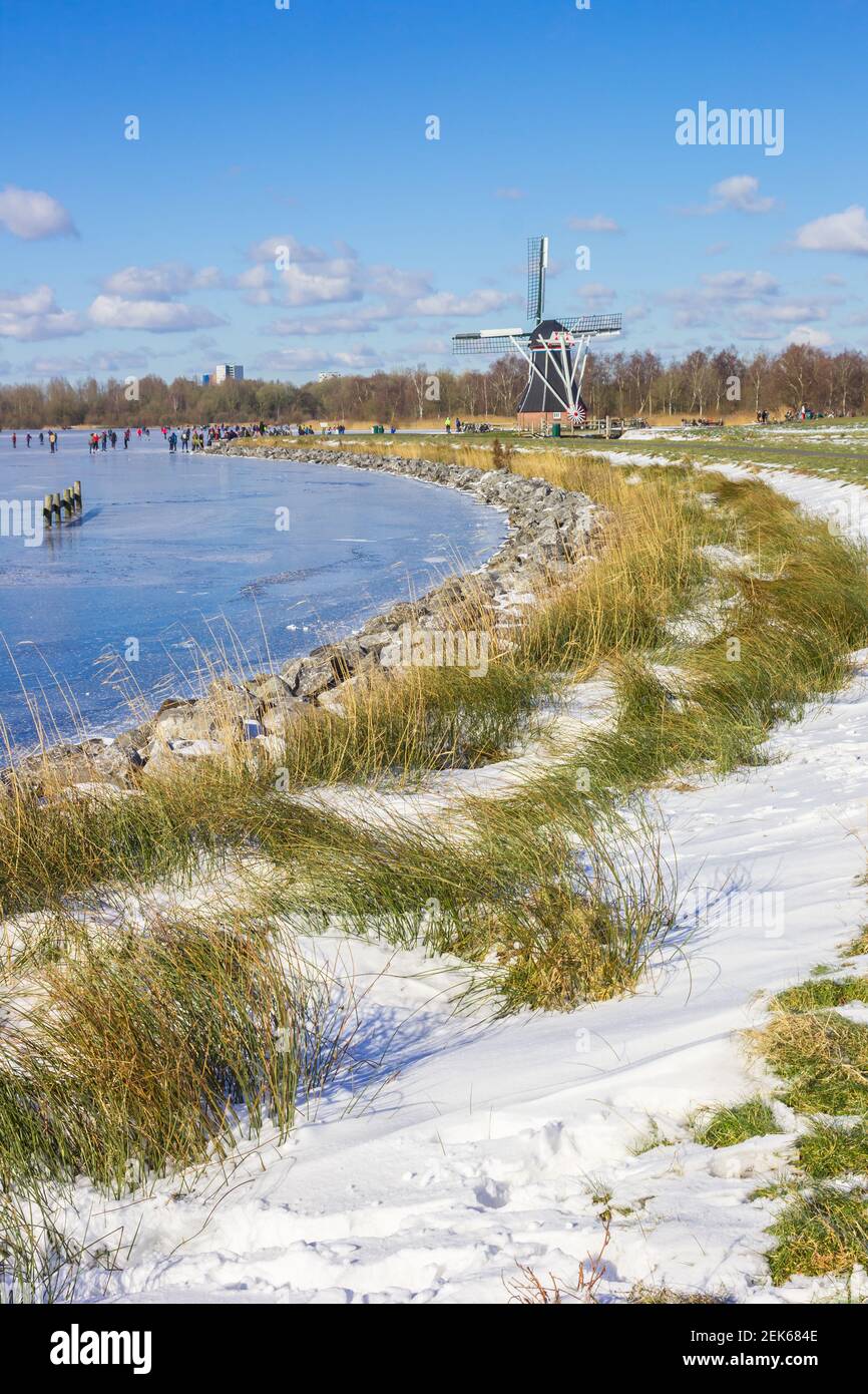 Moulin à vent historique sur le lac gelé à Paterswolde, pays-Bas Banque D'Images