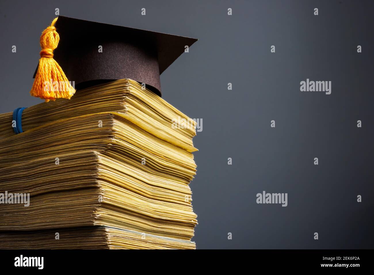 Concept du coût de l'éducation. Plafond de remise des diplômes et pile d'argent pour l'université. Banque D'Images