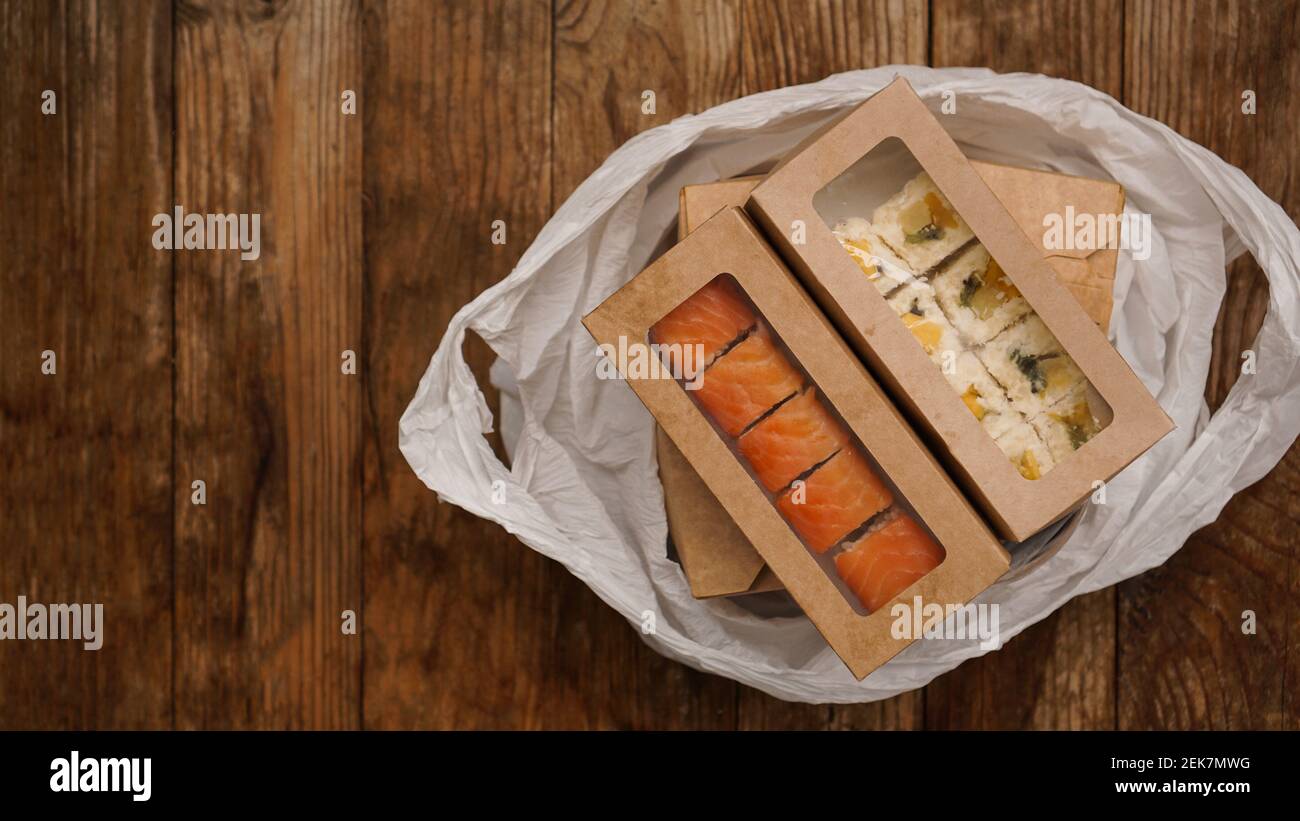 Livraison de nourriture asiatique. Nourriture dans des récipients et dans un emballage sur fond de bois. Nourriture japonaise et emballage sushi. Banque D'Images